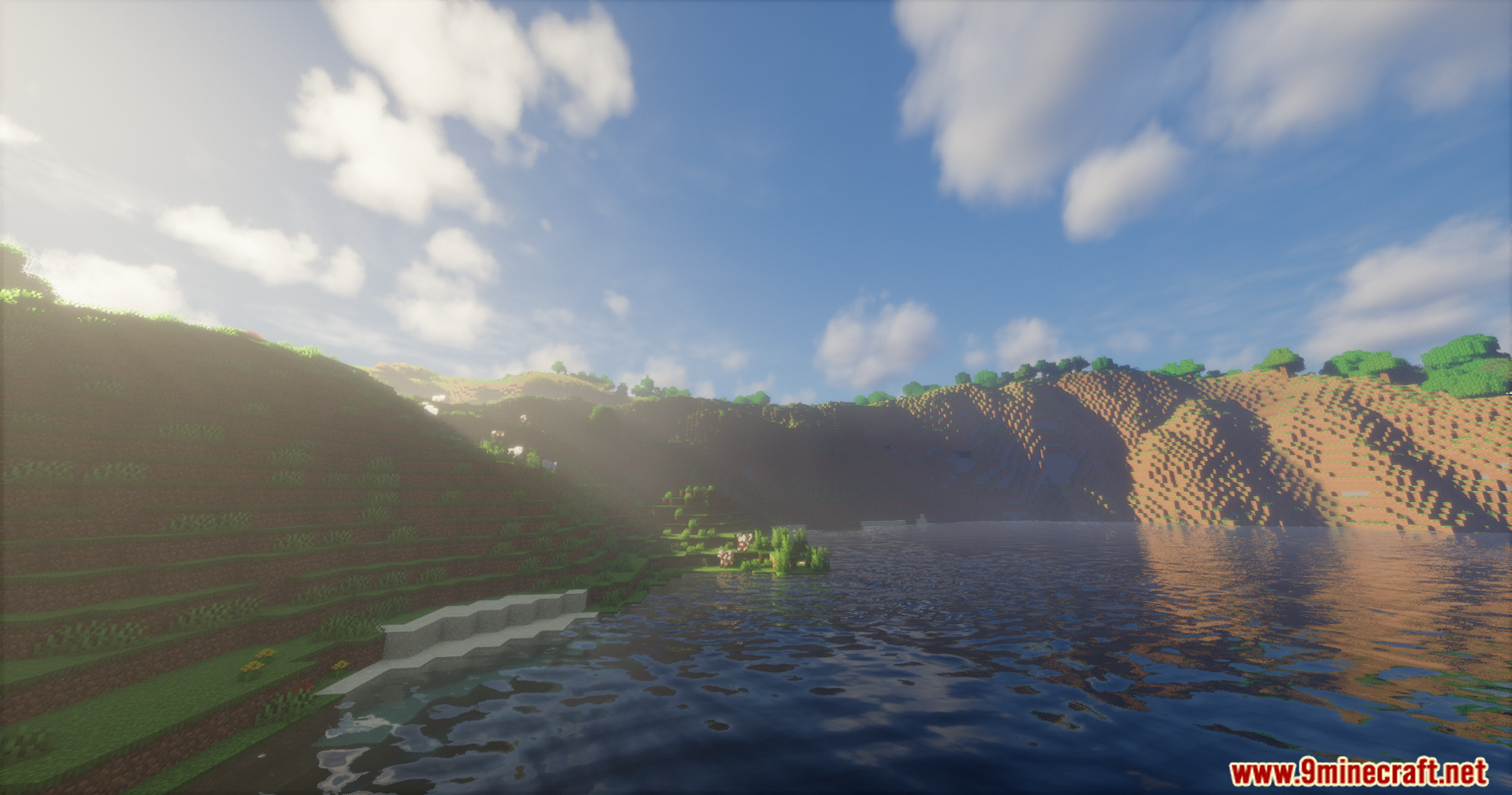 Soft sunlight illuminating a grassy hillside next to rippling water