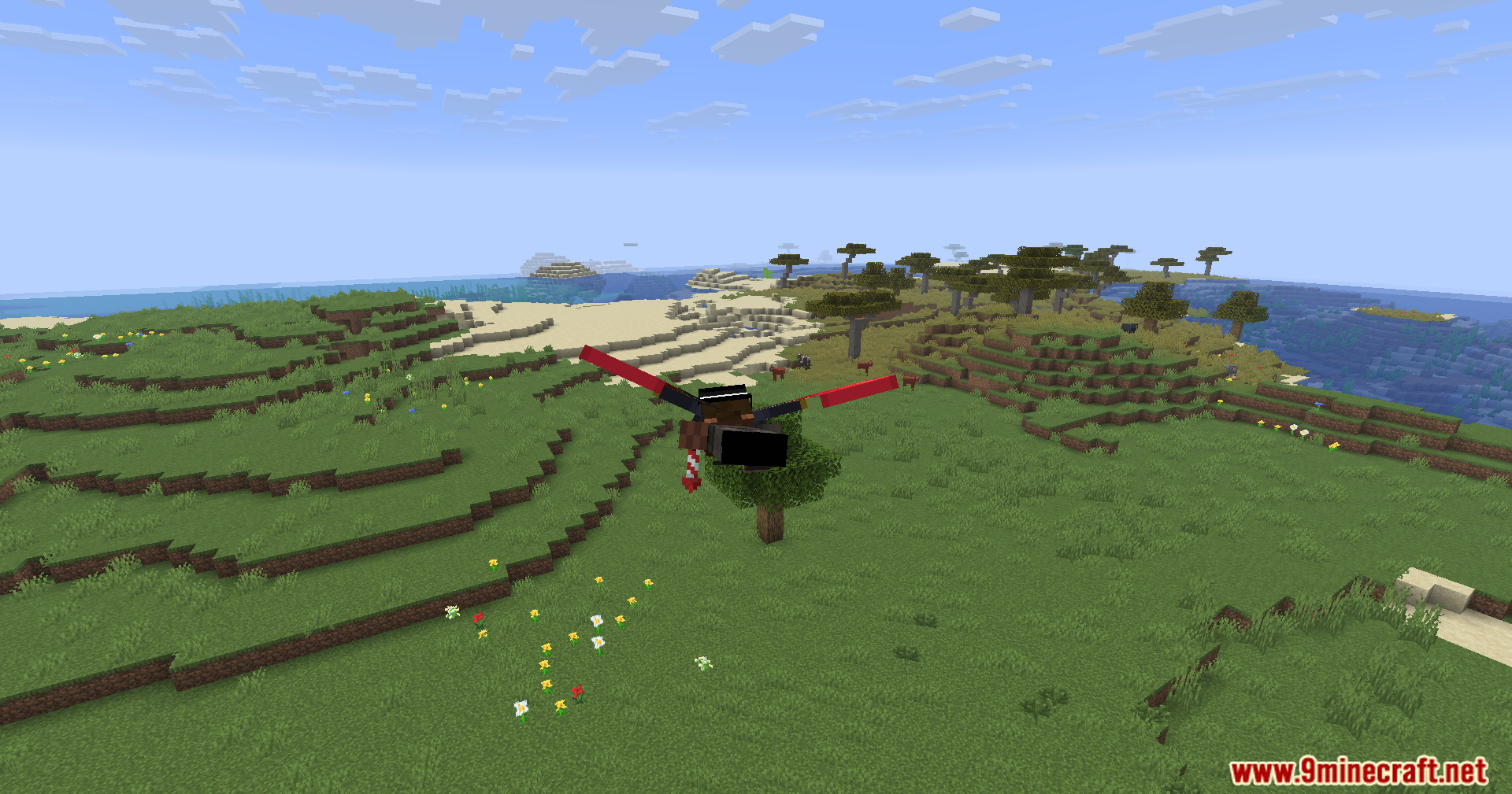 Player flying over a green landscape with red wings