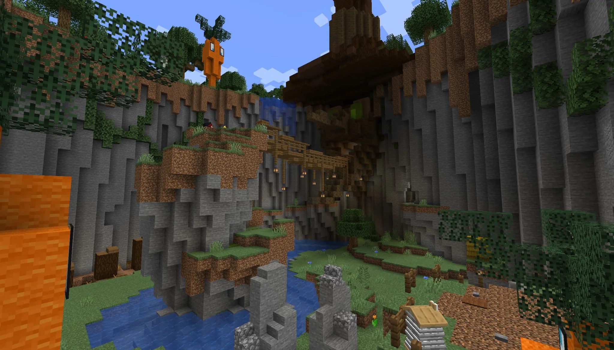 Wooden bridge over a river in a valley with a giant carrot statue