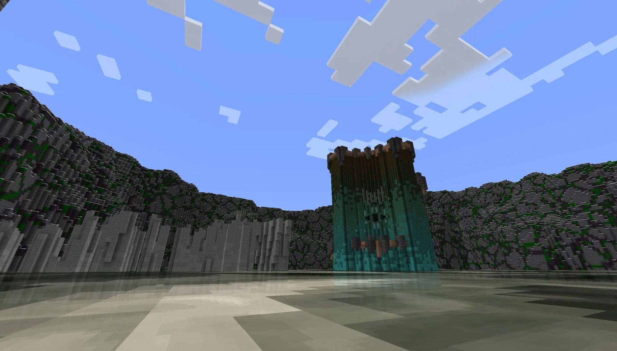 A tall teal tower stands in a rocky valley under a bright blue sky