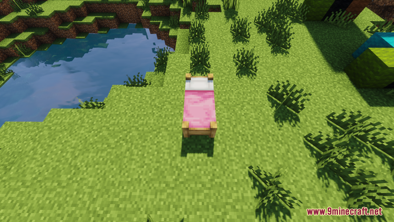 A pink bed with a thick mattress sitting near a small pond