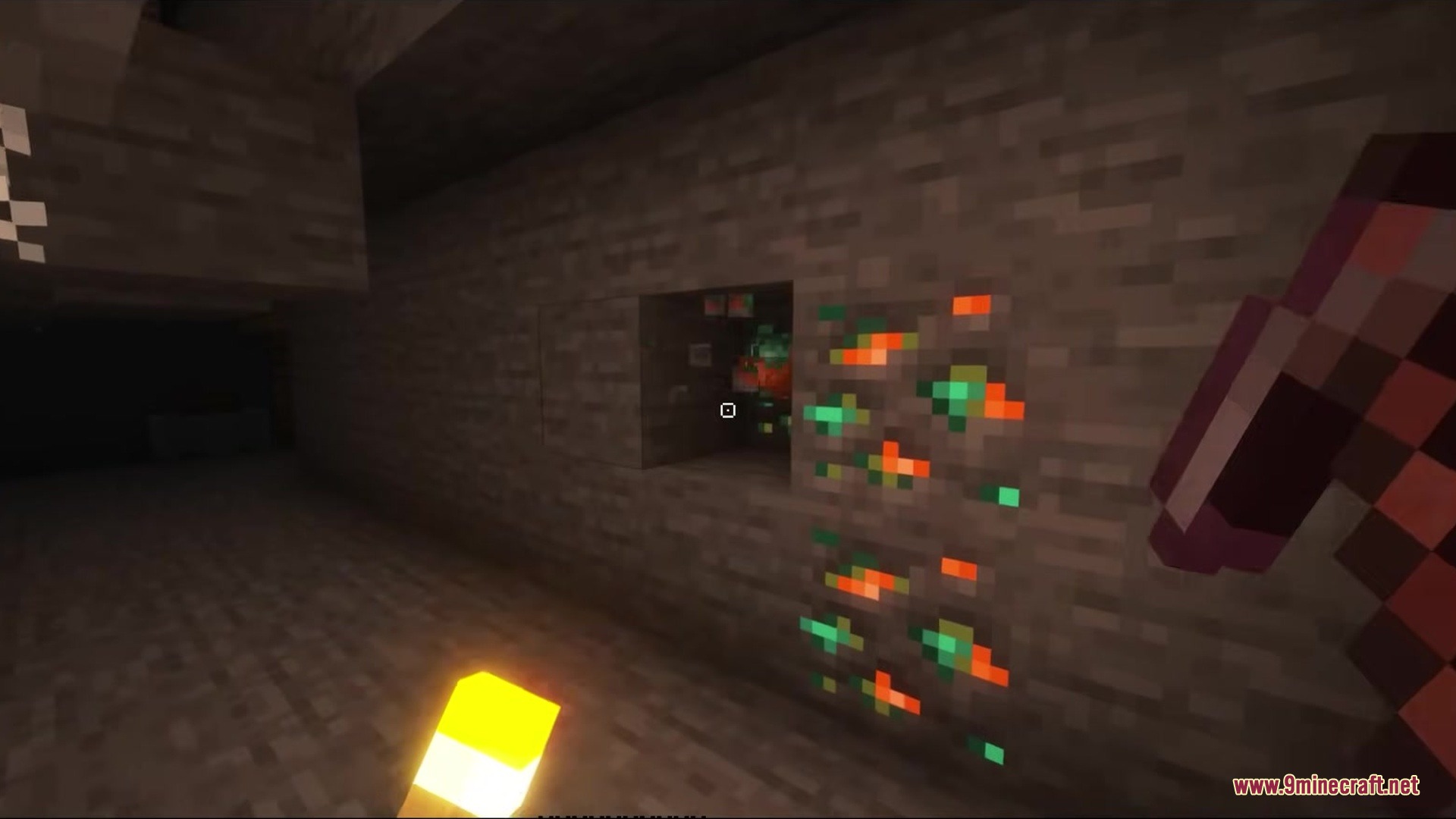 The square crosshair points at glowing orange and green ore in a cave