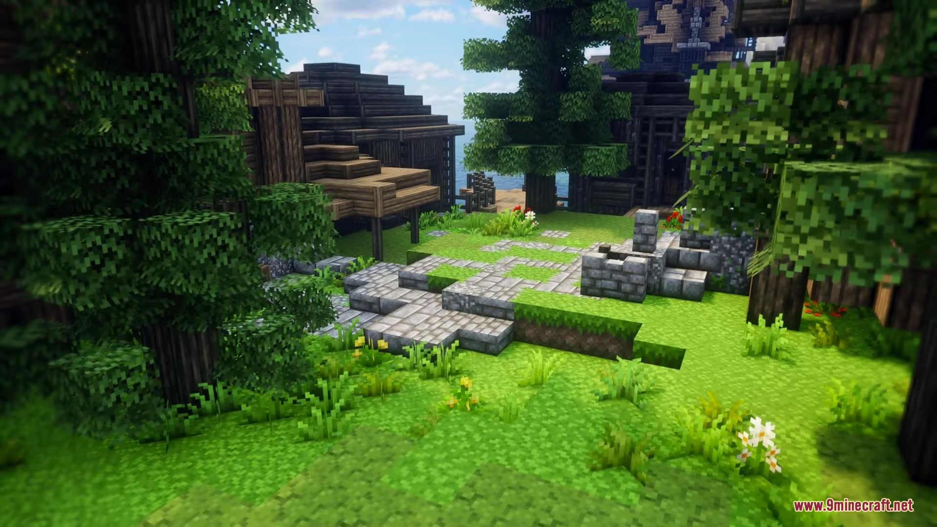 Medieval wooden buildings surrounded by lush green grass and stone pathways