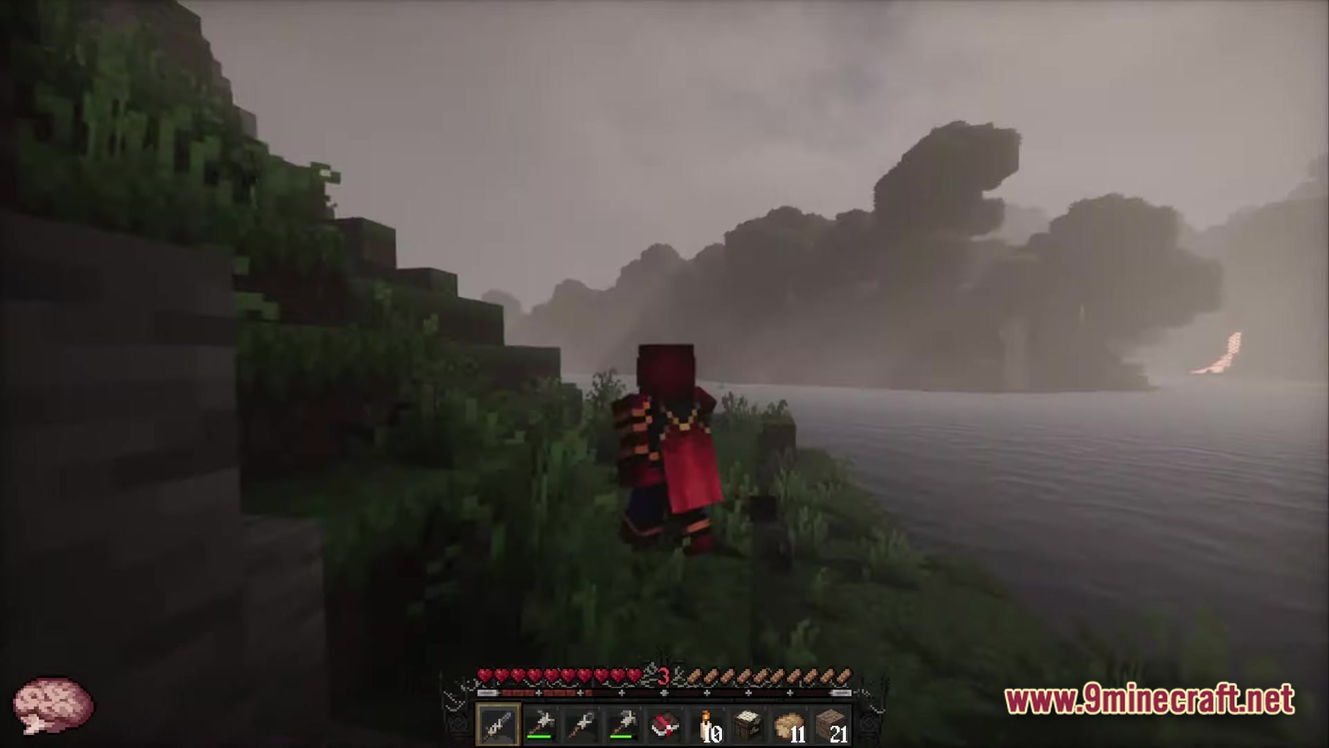 Fear Nightfall Remains Of Chaos Modpack (26.2, 1.20.1) – Survive The Endless Nightmare 2 A player character in red armor stands on a grassy riverbank overlooking a foggy mountain landscape