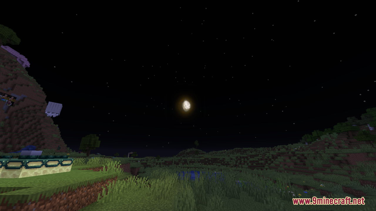 A detailed full moon shines in the night sky above a grassy landscape