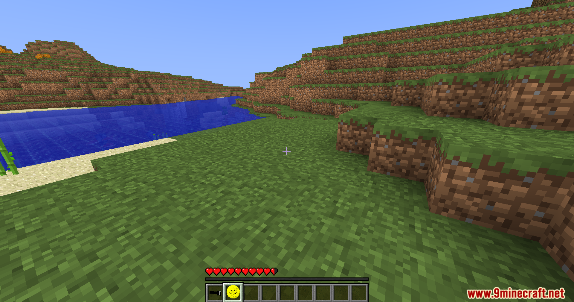 Verity Shaders (1.20.1) – Smooth Sphere Rendering For The Verity Mod 10 A player standing on grass near water with a smiley face item selected