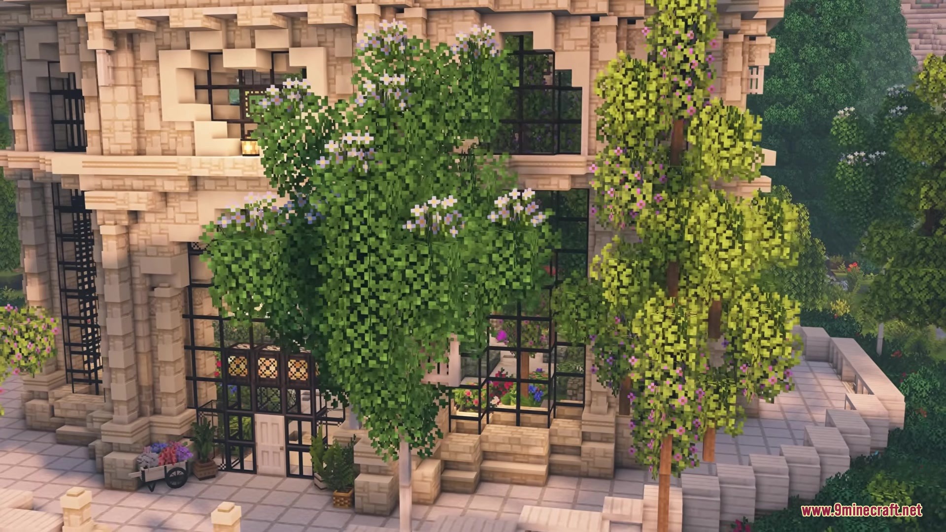 Elegant stone building with large windows surrounded by lush flowering trees