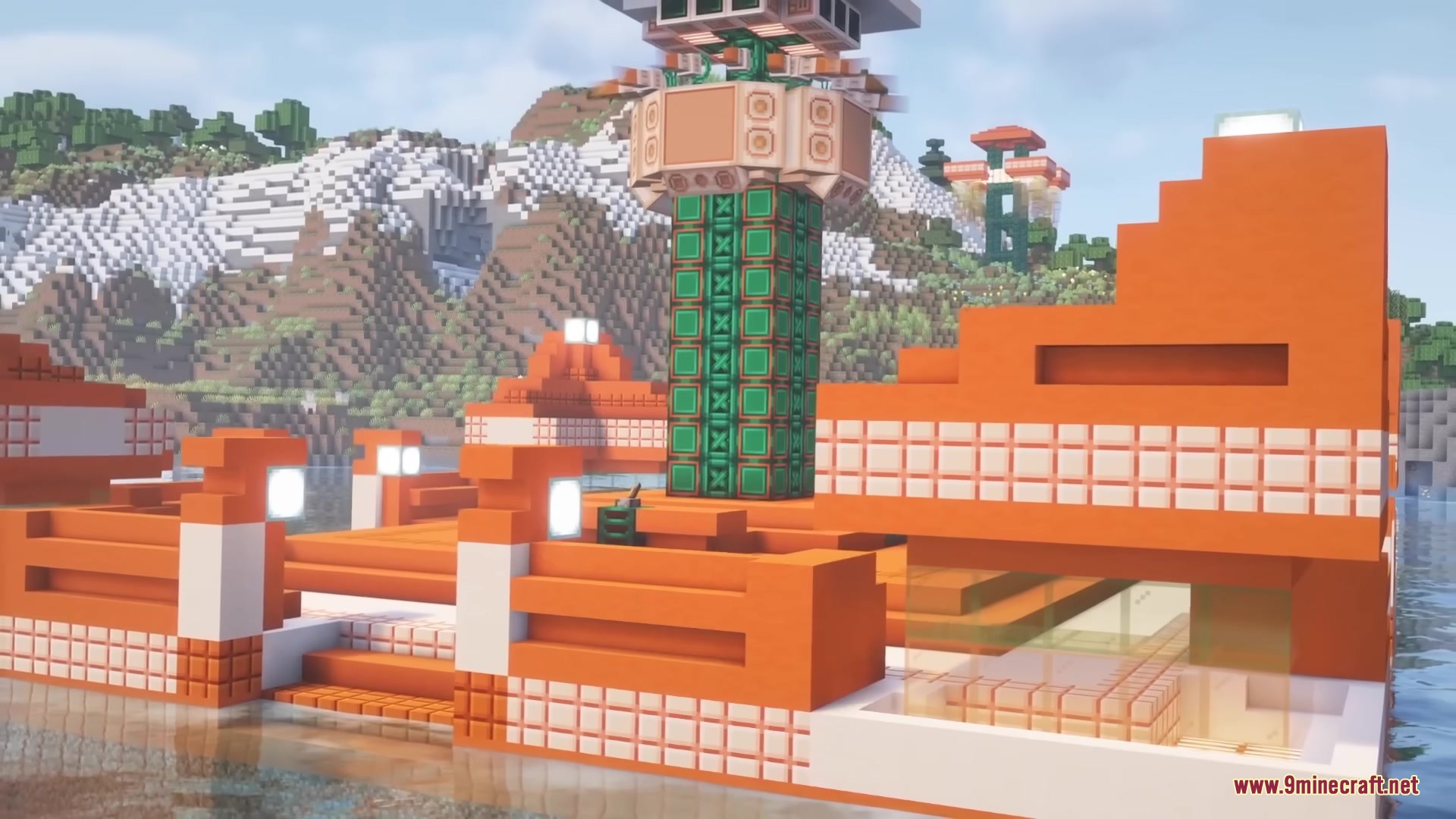 A futuristic orange base with a green tower standing near the water