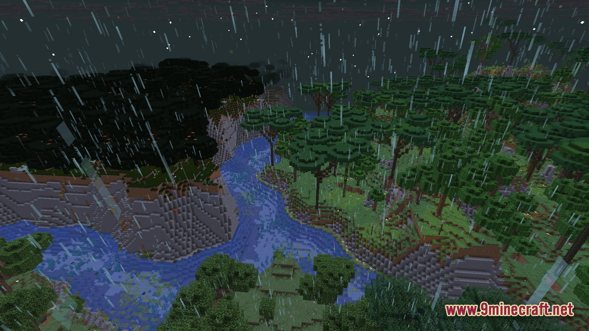 A winding river flows through a forested valley during a heavy rainstorm at night