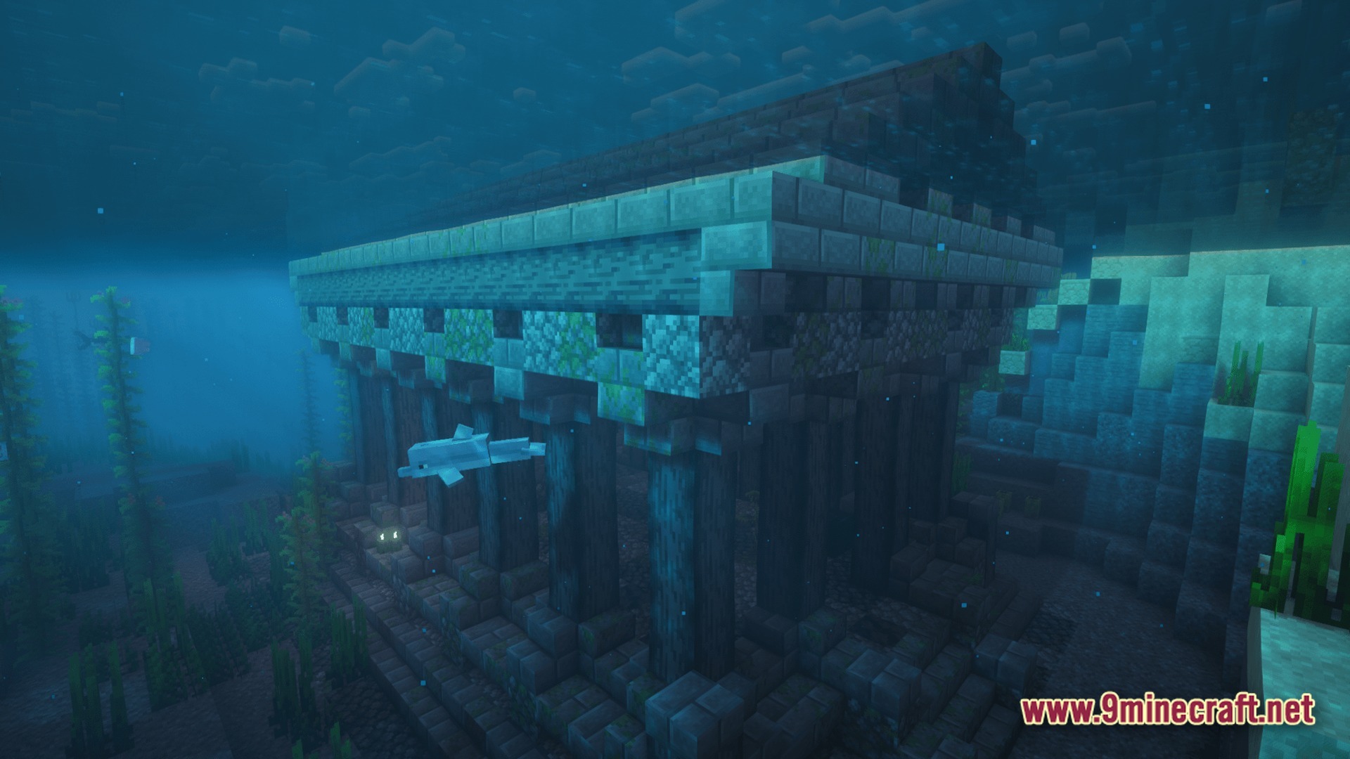A dolphin swims past a large stone temple ruin located on the ocean floor