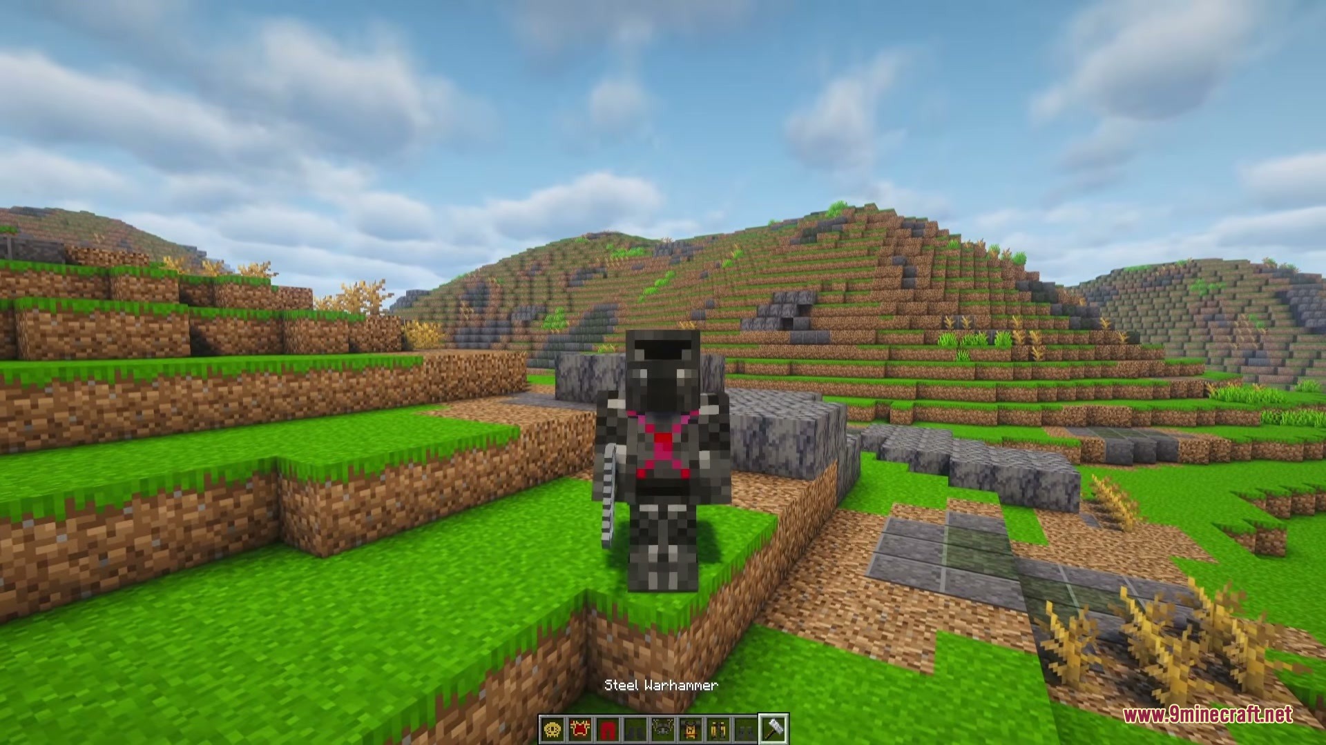 A Game Of Blocks Mod (1.21.1) – Rule Your Own Medieval Kingdom 2 Minecraft character wearing faction armor and holding a steel warhammer in the hills