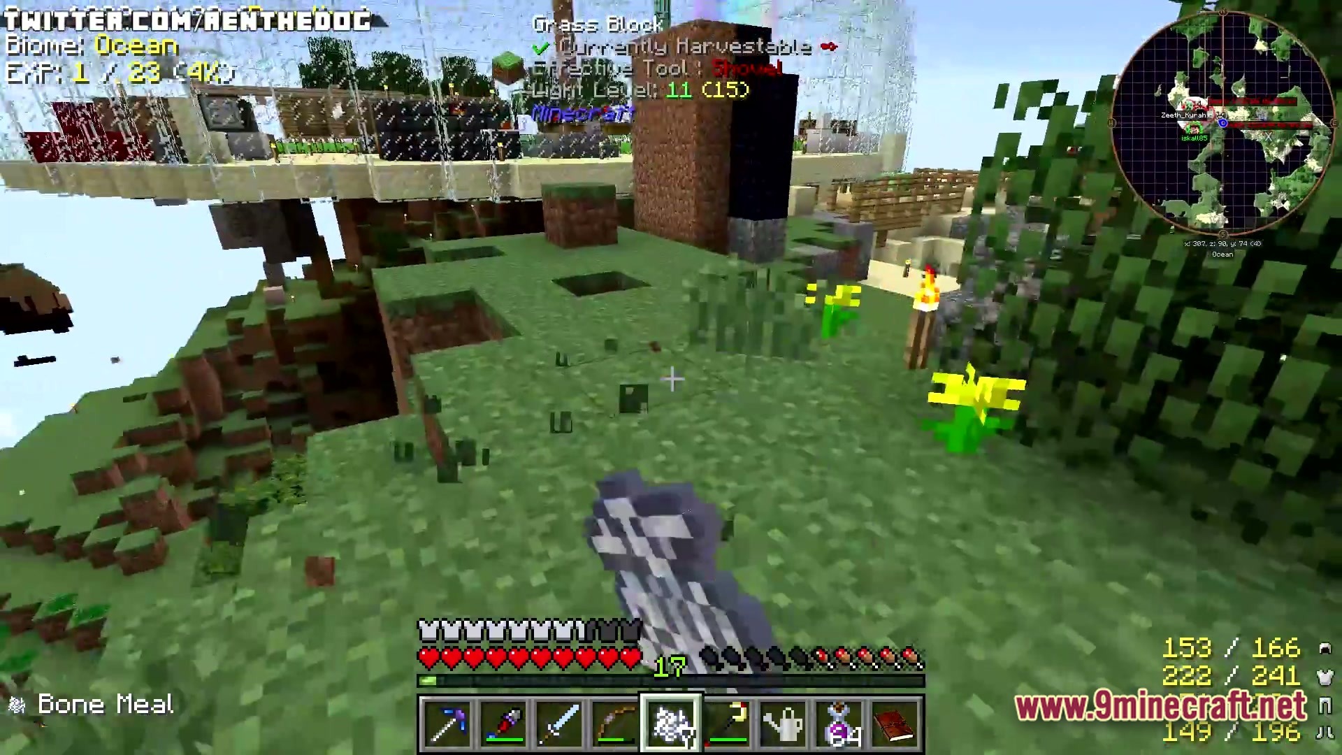 A player holds bone meal on a floating island base with various machines and a minimap