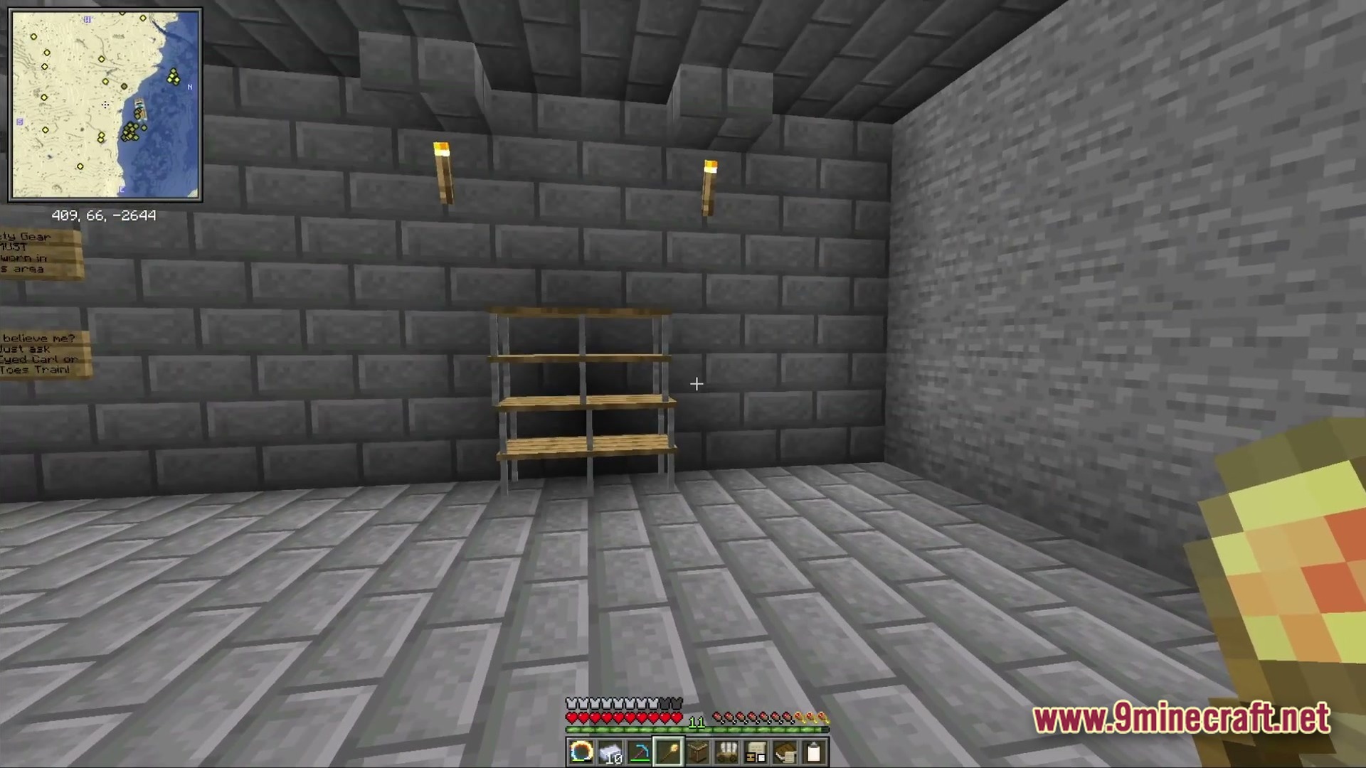 Ancient Kingdoms 3 Modpack (1.20.1) – Build Kingdoms Master Magic Slay 6 A stone brick room featuring empty wooden shelves, wall torches, and signs near a corner