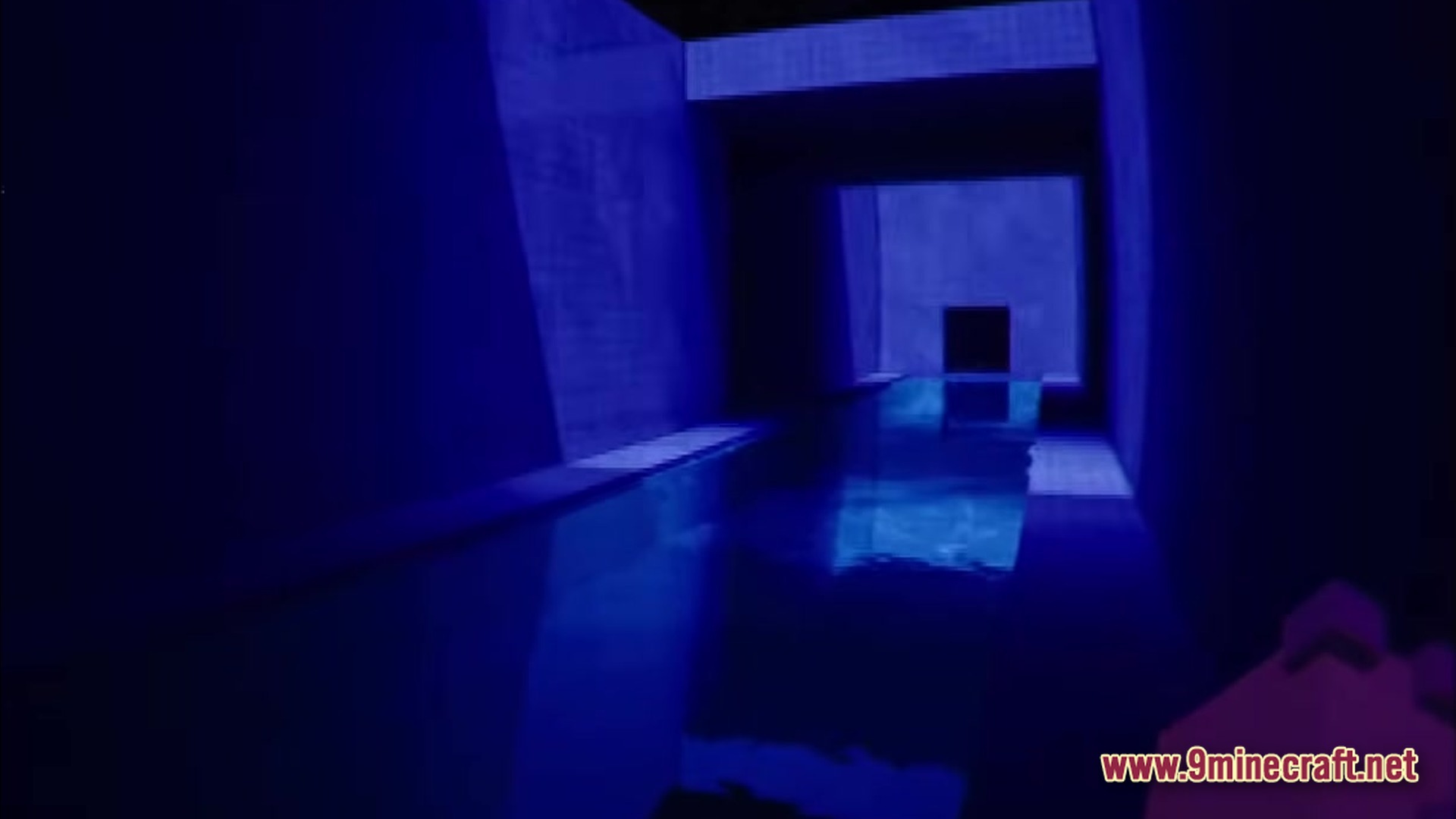 A dark, blue-lit indoor pool area with concrete walls and reflective water in a narrow corridor