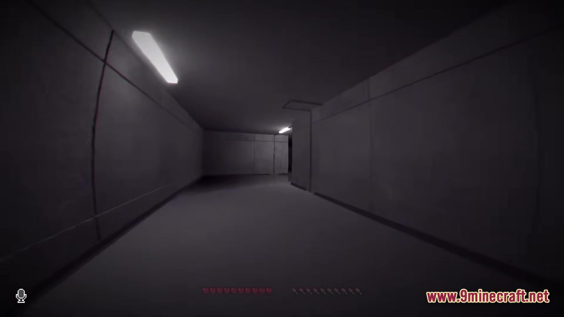 A first-person perspective of a dimly lit, concrete hallway with fluorescent lights and a vhs-style overlay
