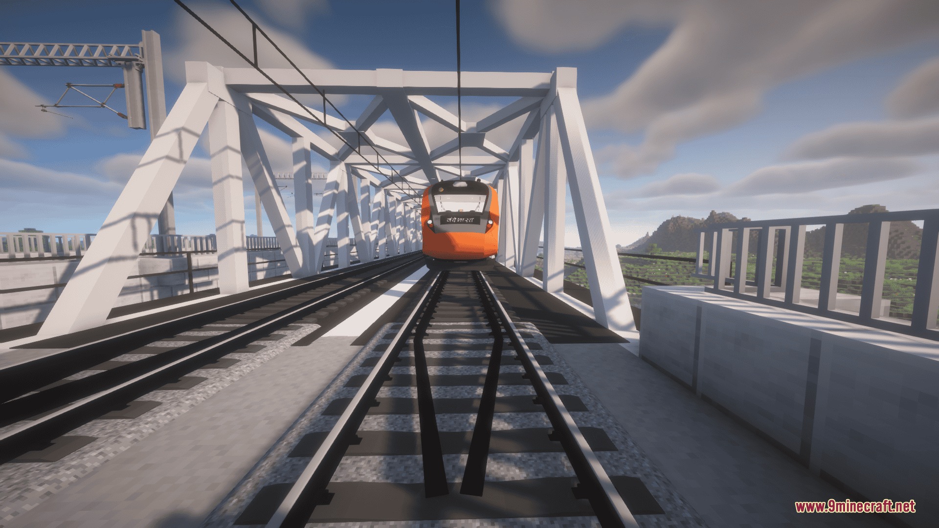Front view of a modern orange train on a white metal bridge