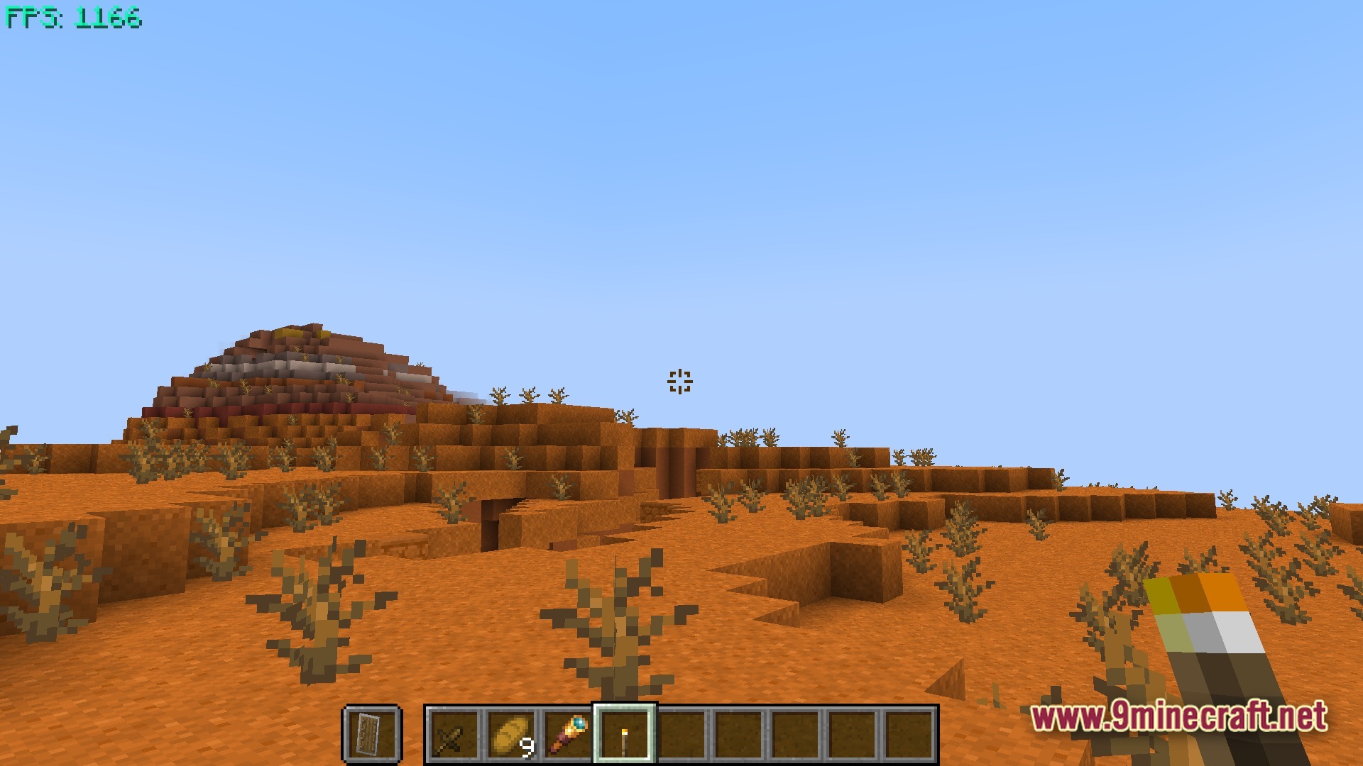 Boosted Fps Performance Optimized Modpack (1.20.1) – Supercharge Your Game Speed 11 A first-person view of a player holding a torch in a desert badlands biome with high fps