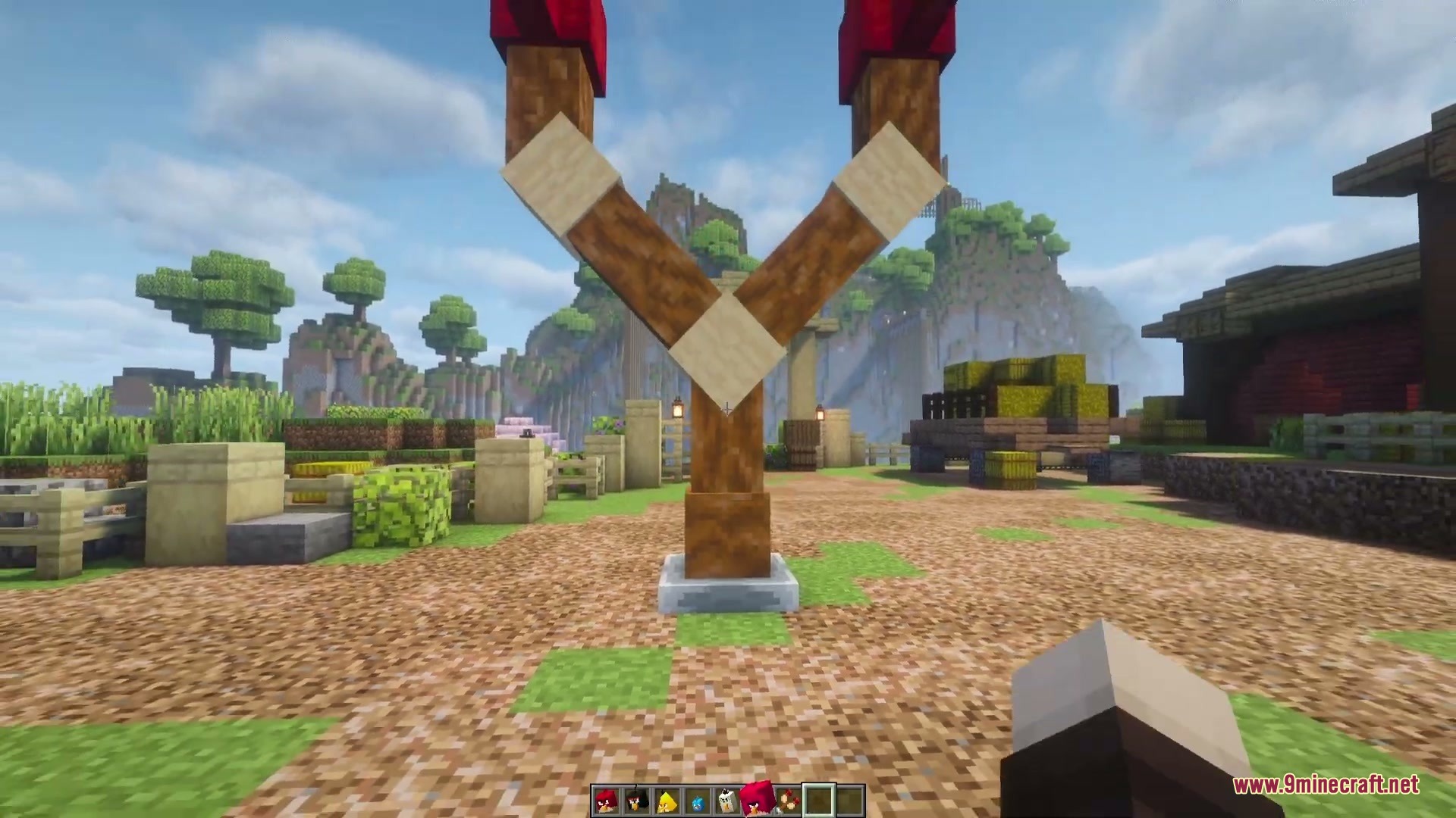 Citrus Wings Mod (1.21.1) – Launch Powerful Birds To Demolish Custom Towers 3 A large wooden slingshot built on a stone base in a village
