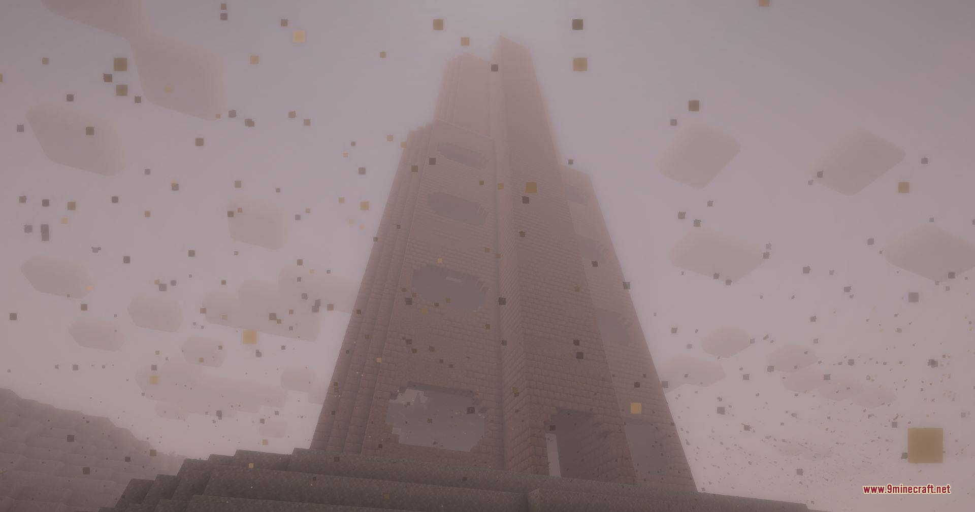 Looking up at a massive brick tower stretching into the thick fog