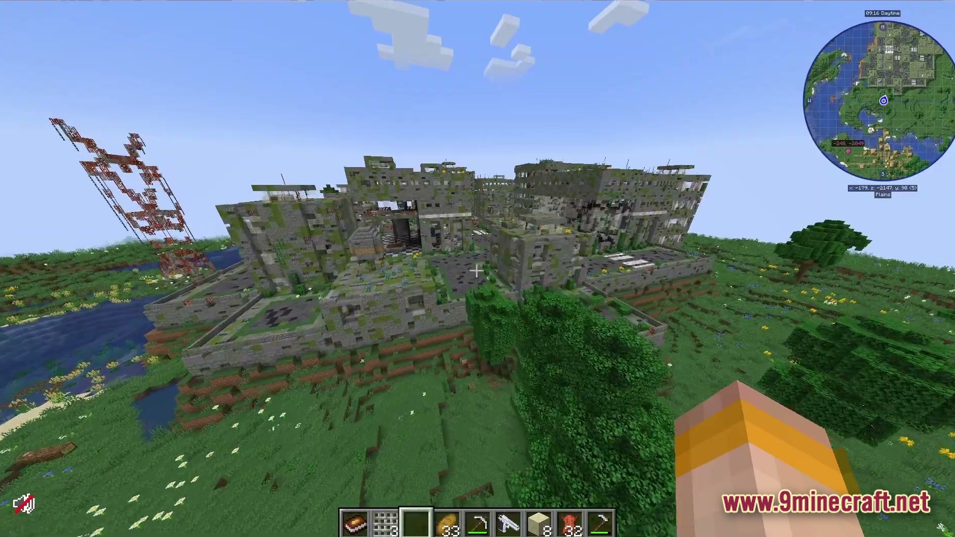 An abandoned, overgrown concrete building complex situated within a grassy plains biome