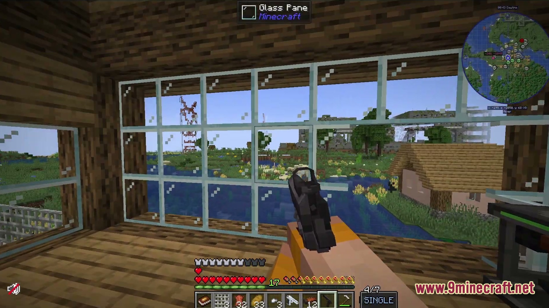 A player holds a handgun while looking through a window at a river and distant structures