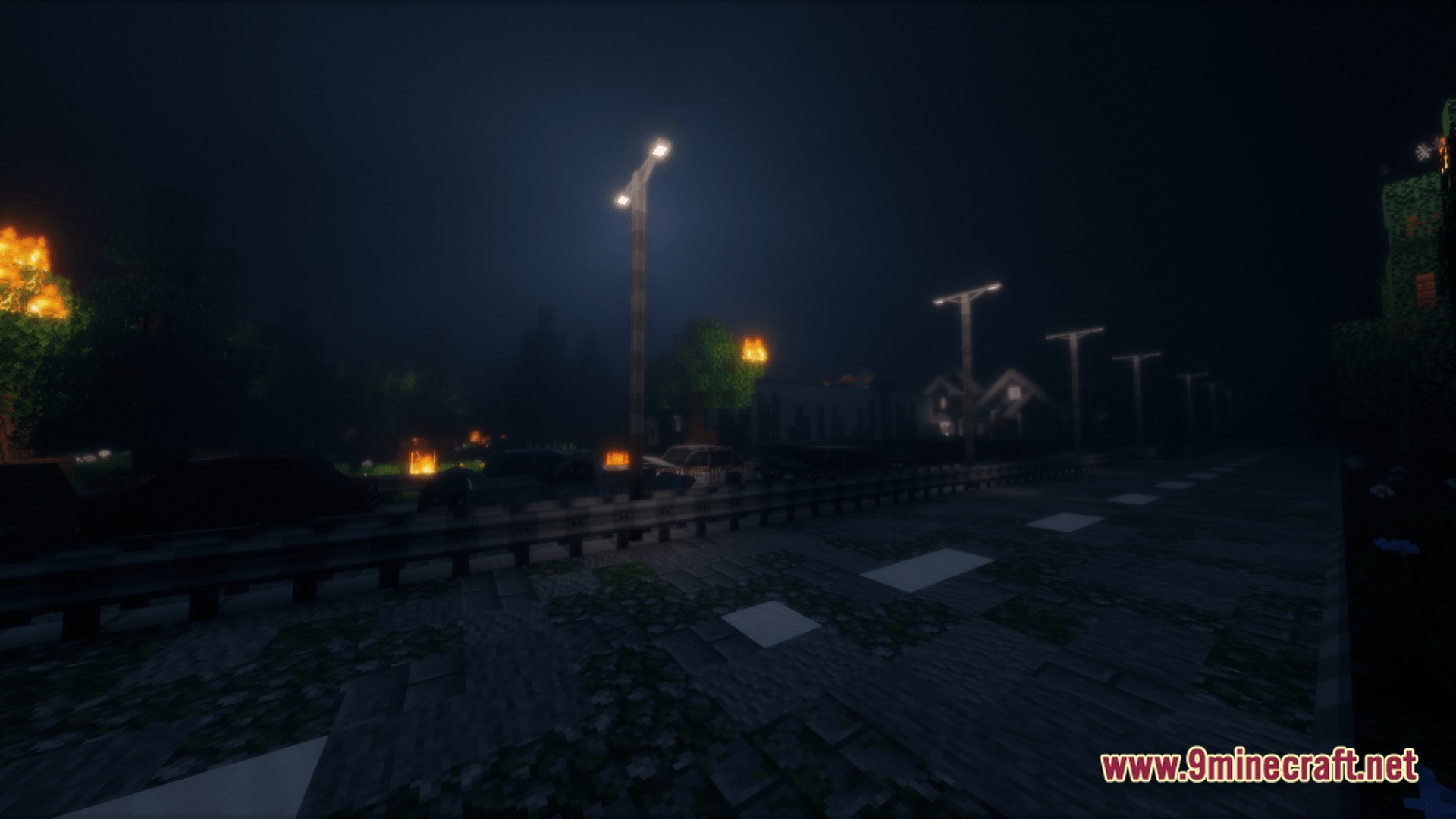 A dark asphalt road lined with streetlights and burning trees in a post-apocalyptic urban environment