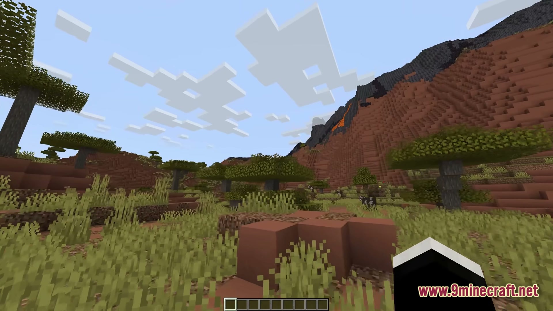 Ff’s Terra Forge Modpack (1.21) – Explore Massive Biomes And Dungeons 2 A savanna biome featuring acacia trees, tall grass, and a large red sand mountain with lava
