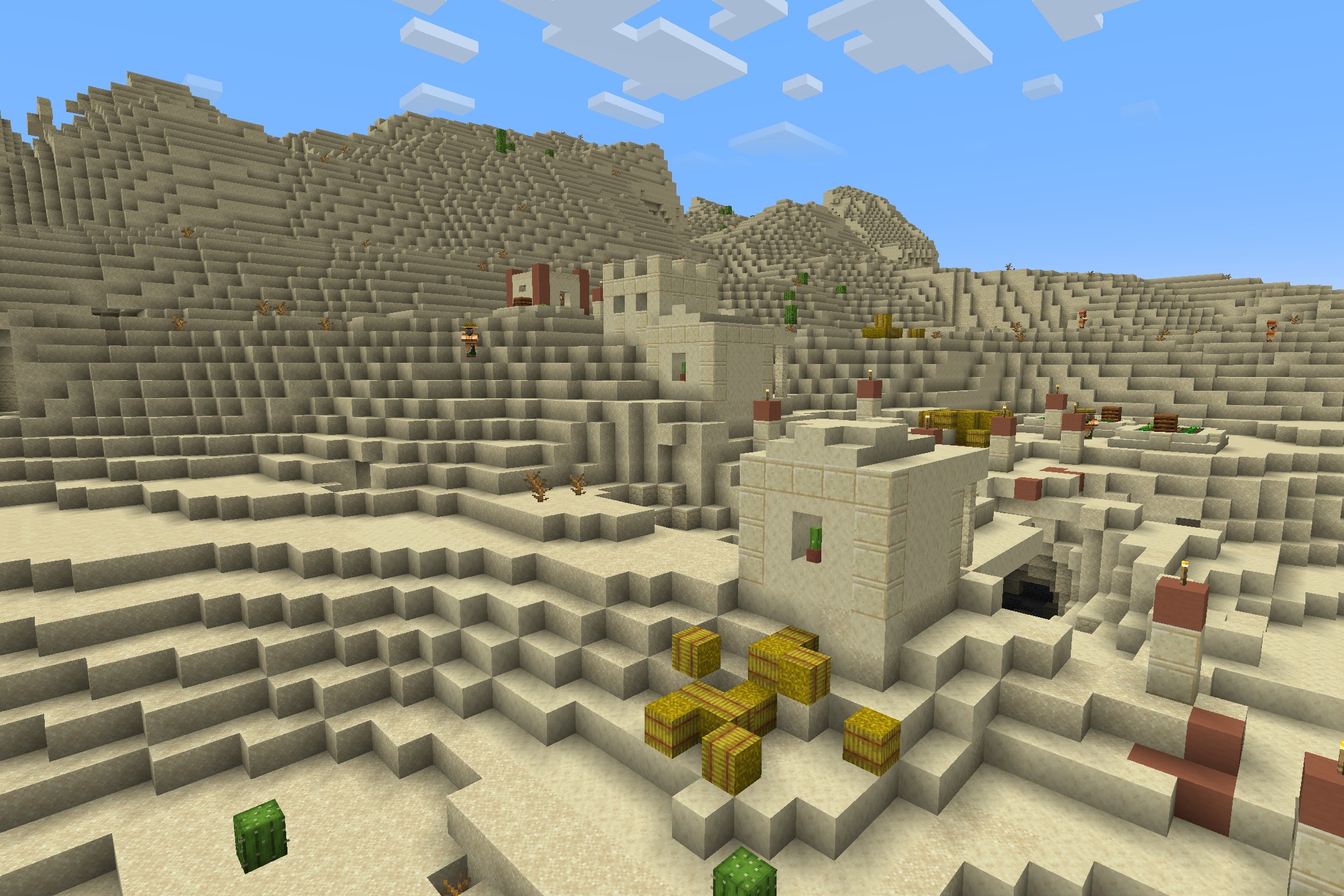 Sandstone buildings and hay bales scattered throughout a desert village in minecraft