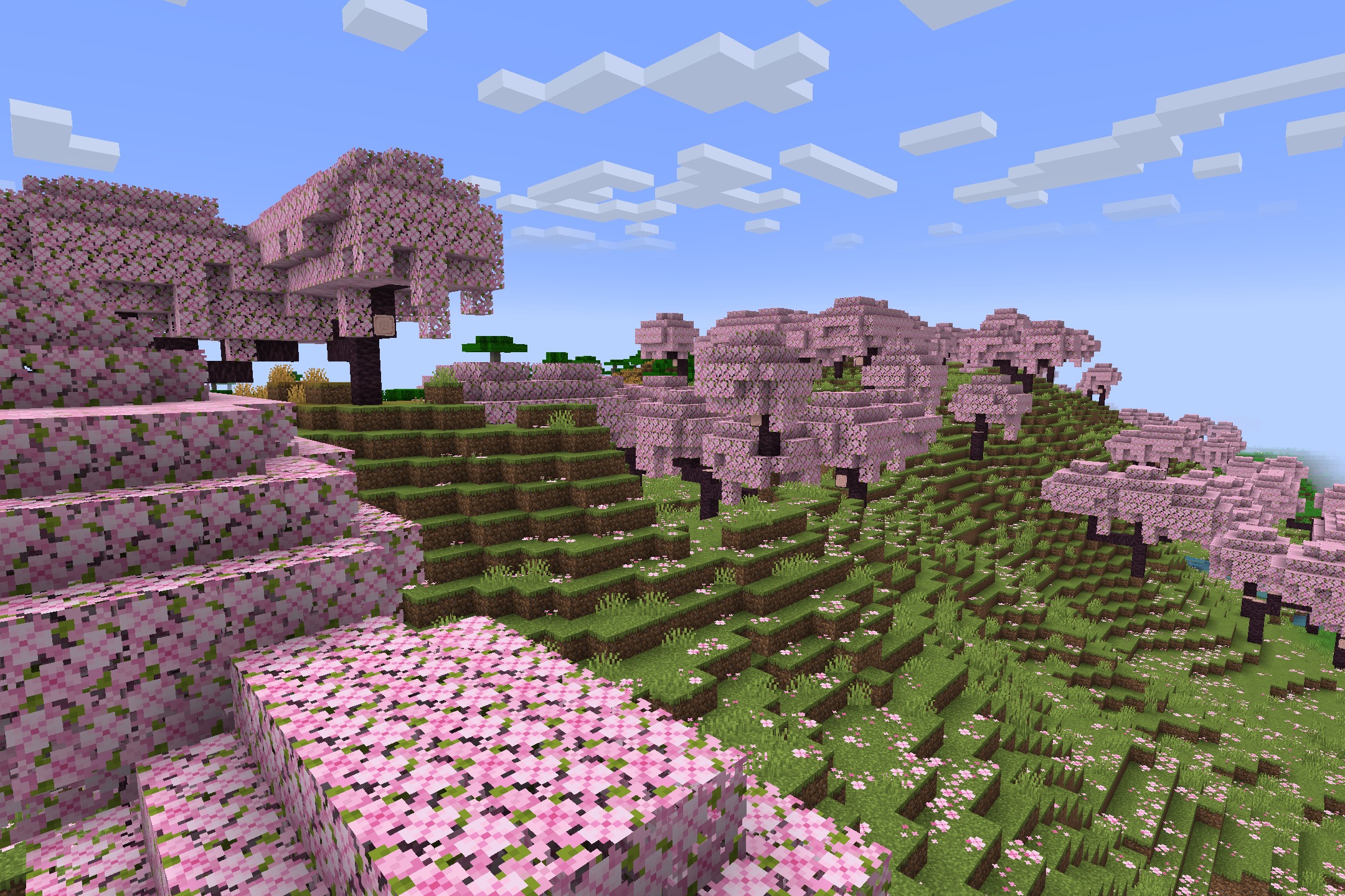 Lush cherry grove biome featuring pink trees and scattered petals on green hills