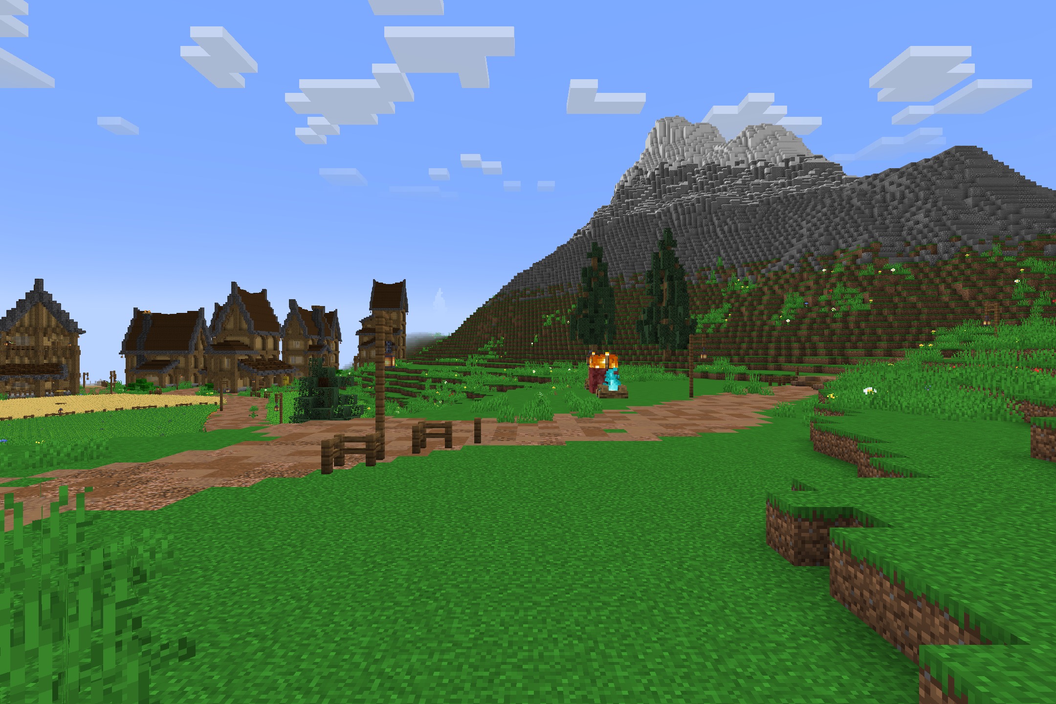 Scenic view of a village with a dirt path leading toward a mountain