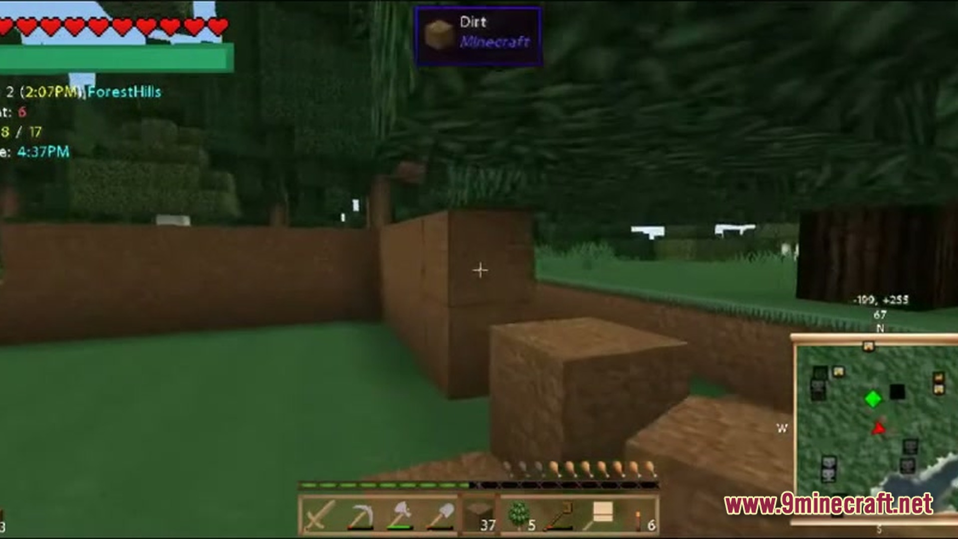 A player builds a dirt structure in a forest biome with a minimap and hud displayed
