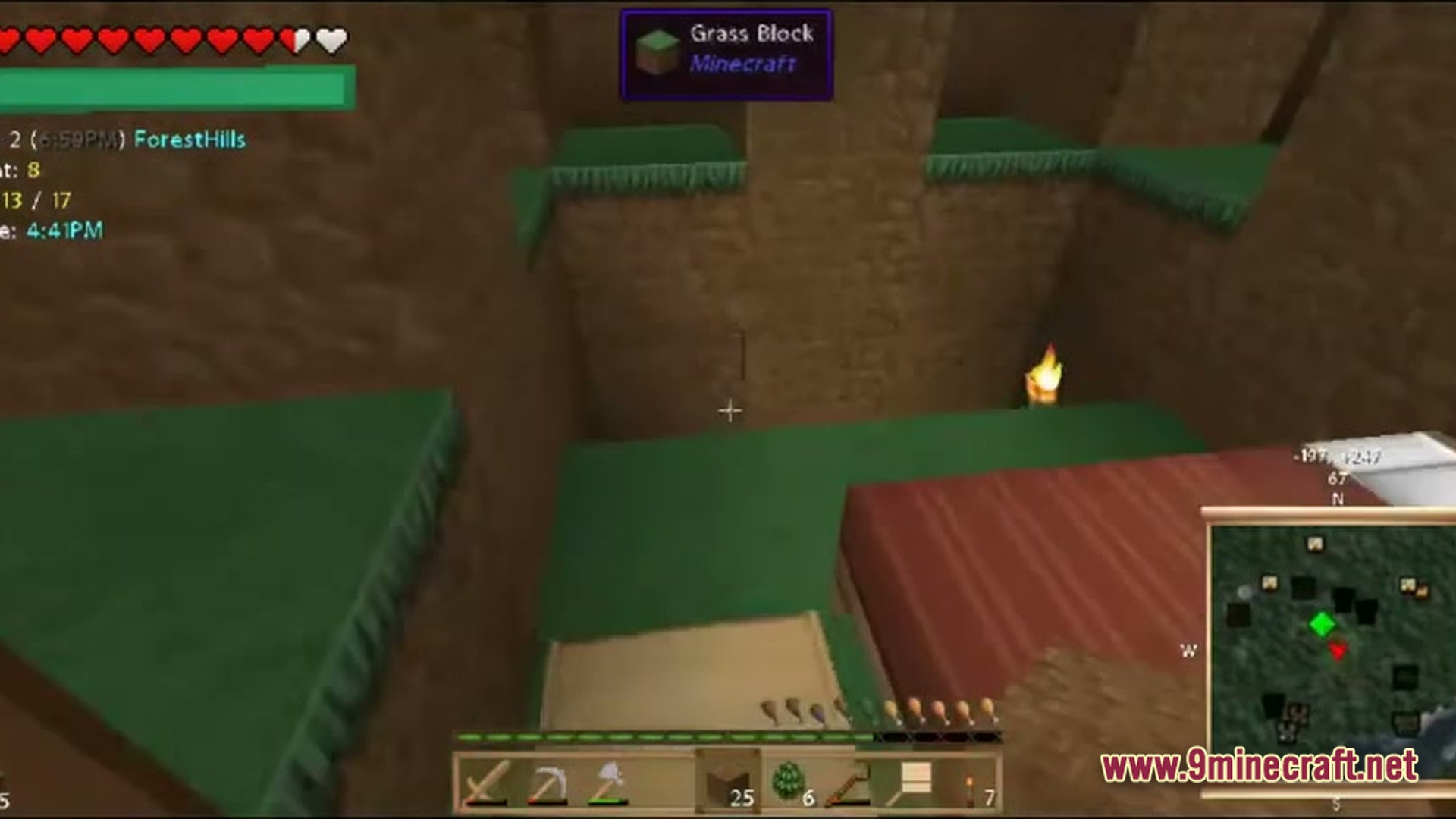 A first-person view of a dirt pit with grass ledges, a torch, and a minimap