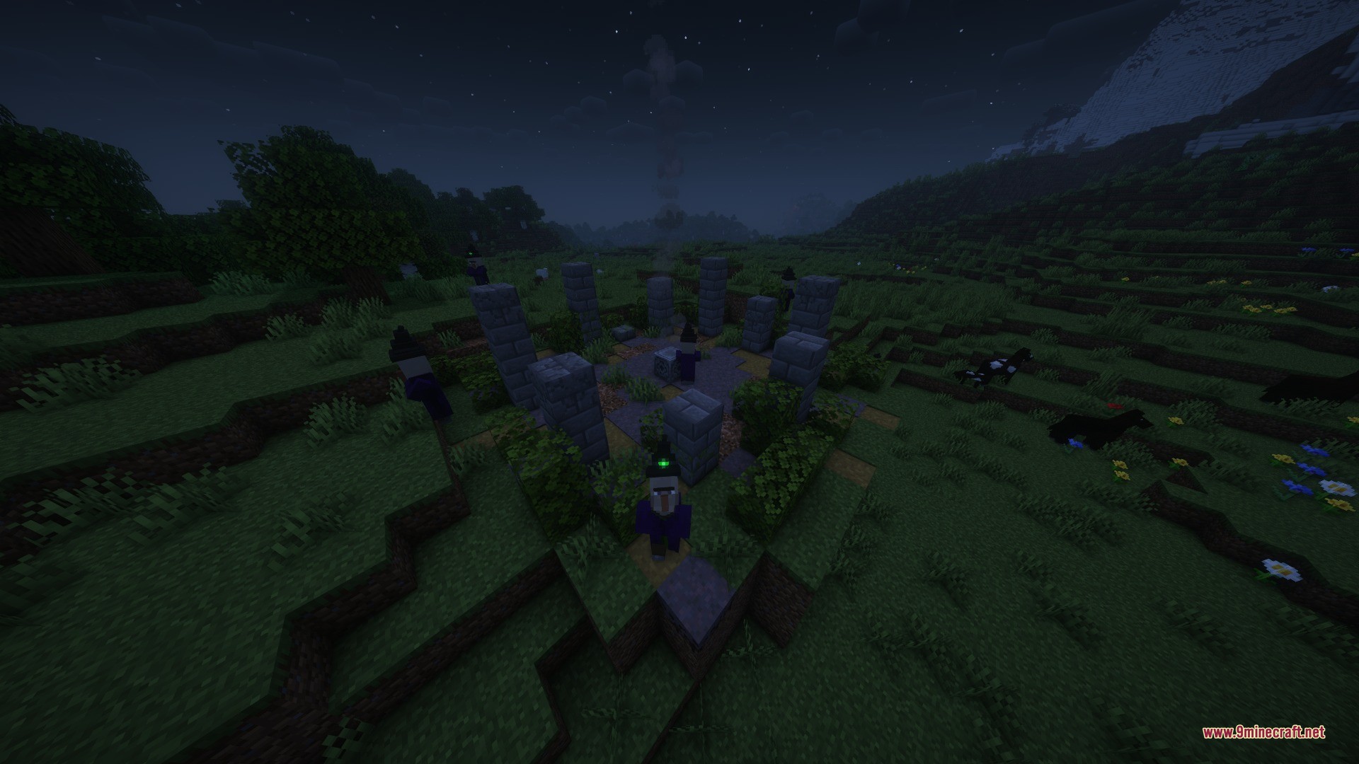 Witches standing around a stone circle monument in a grassy field at night