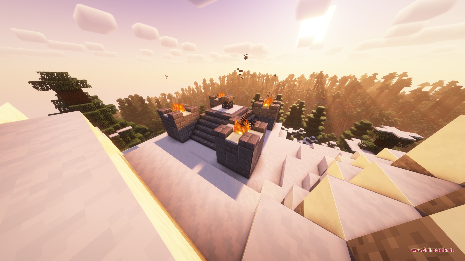 A stone altar with fire pits sits on top of a snowy mountain