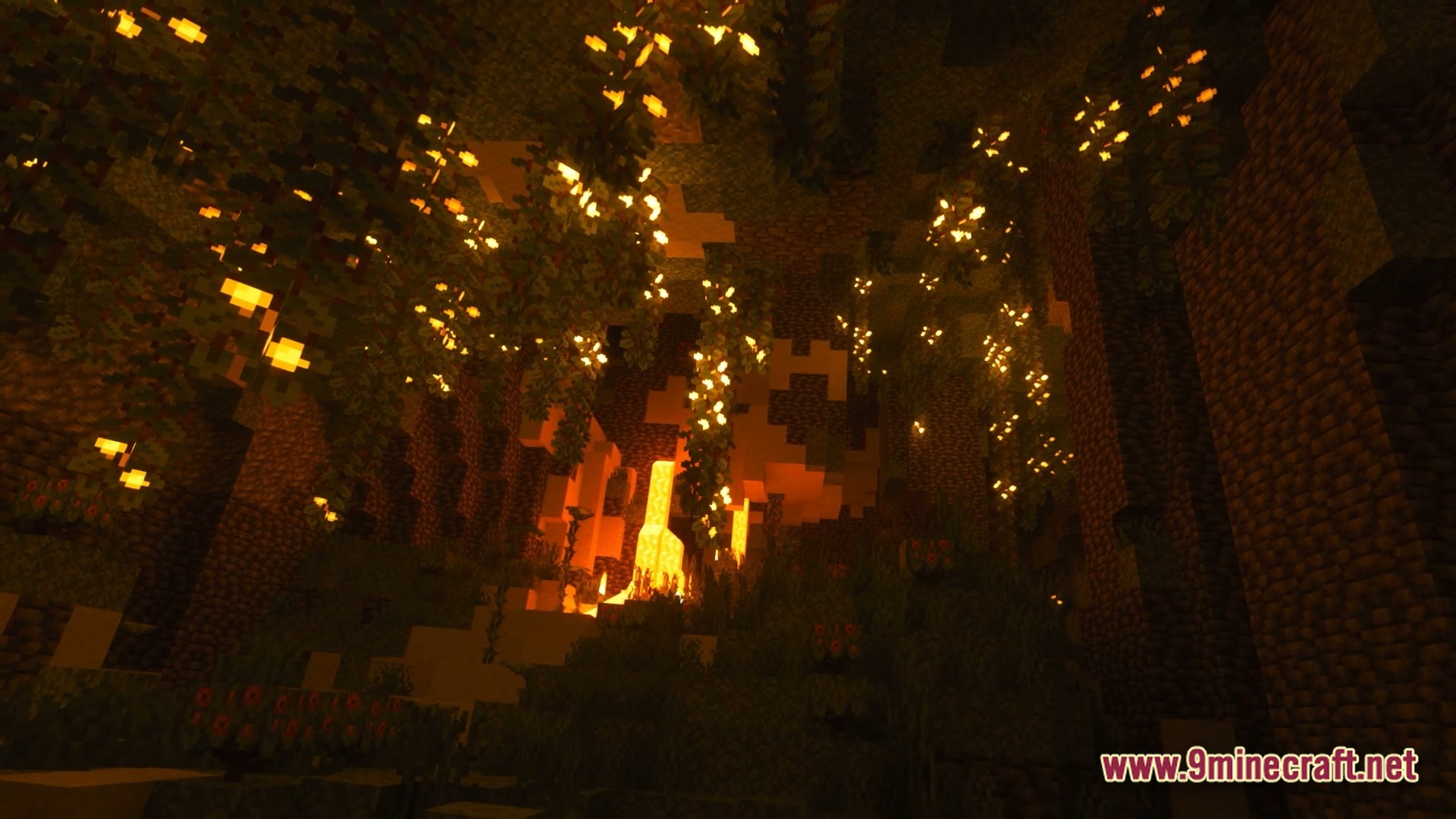 A lush underground cave featuring glowing glow berries, hanging vines, and a distant lava fall