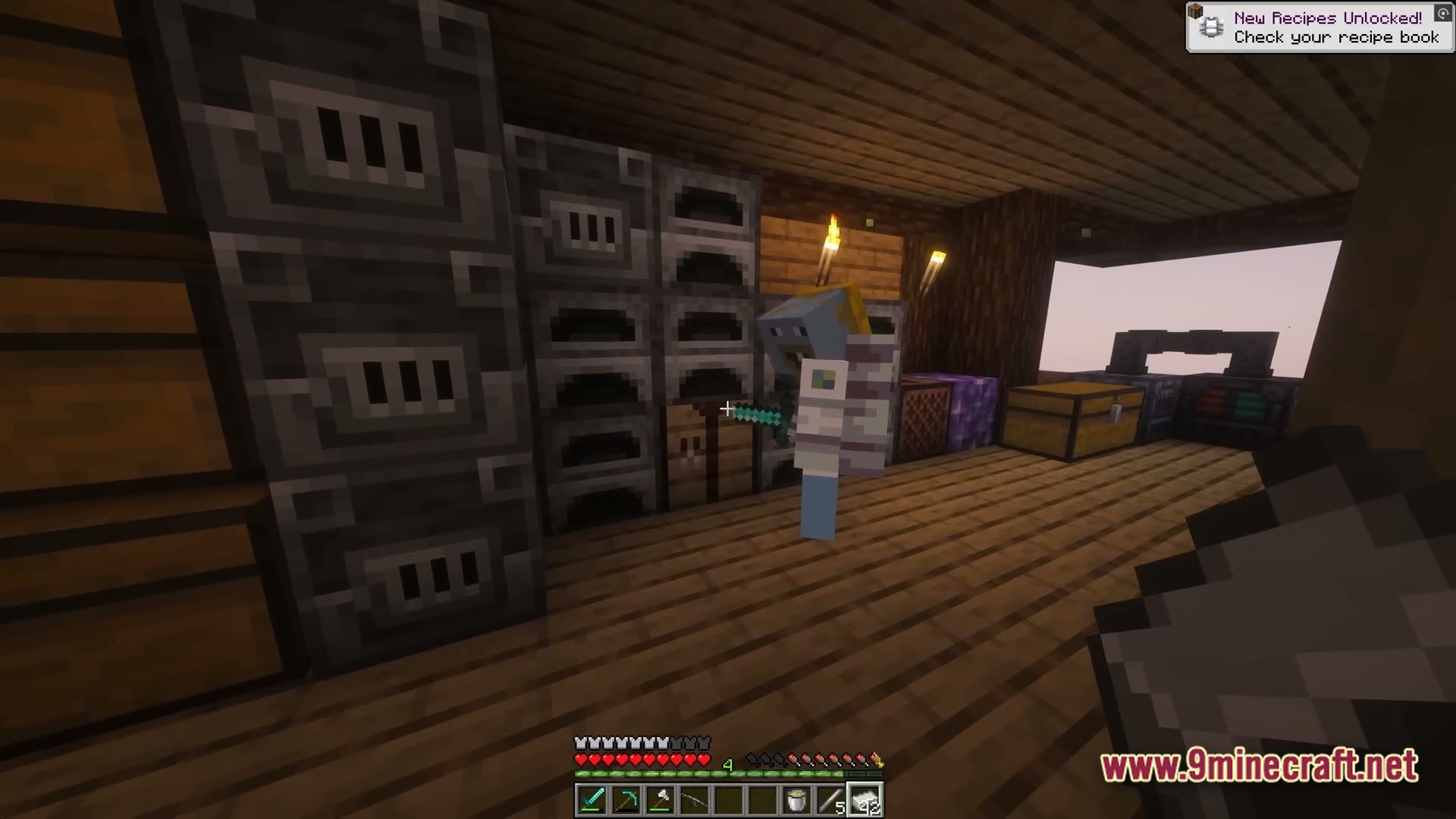 A player stands inside a wooden base featuring various furnaces, storage chests, and industrial machines