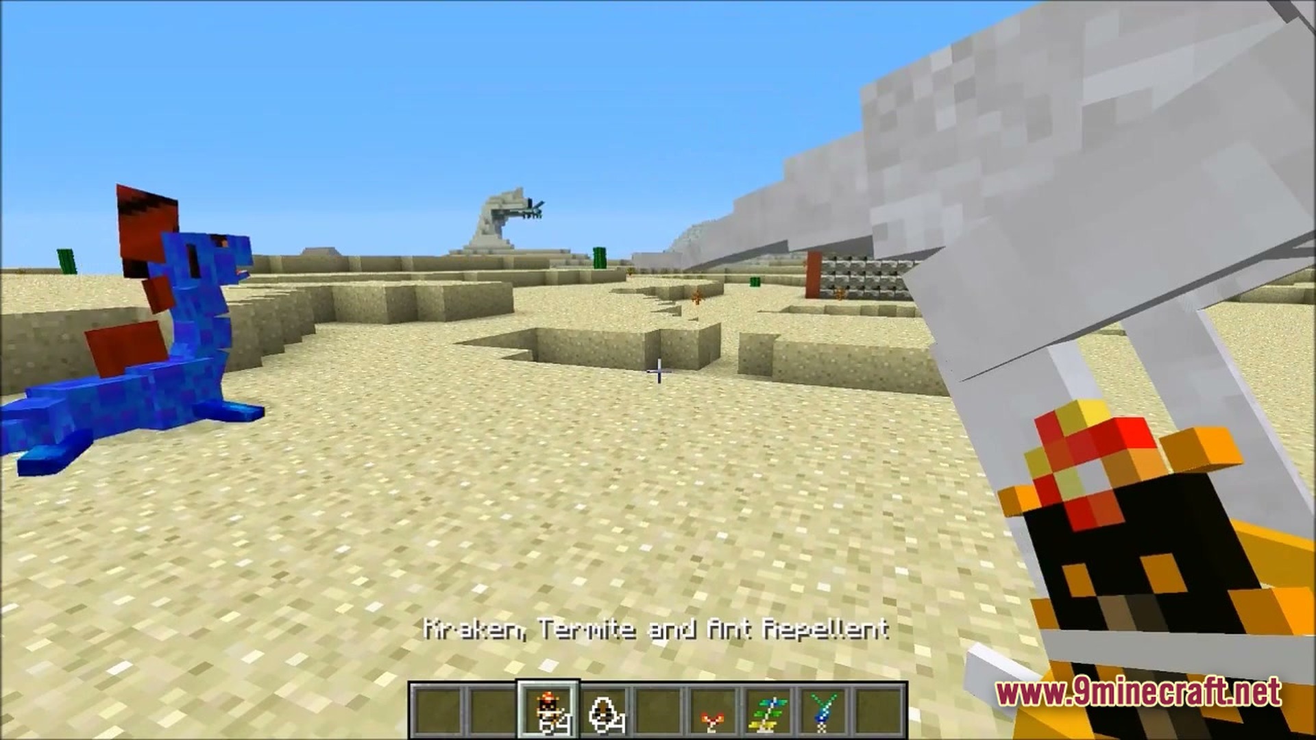 Ore Spawn Adventuree Modpack (1.20.1) – Crazy Dimensions And Giant Beasts 6 A player holds a repellent item while facing a blue dragon mob in a desert biome