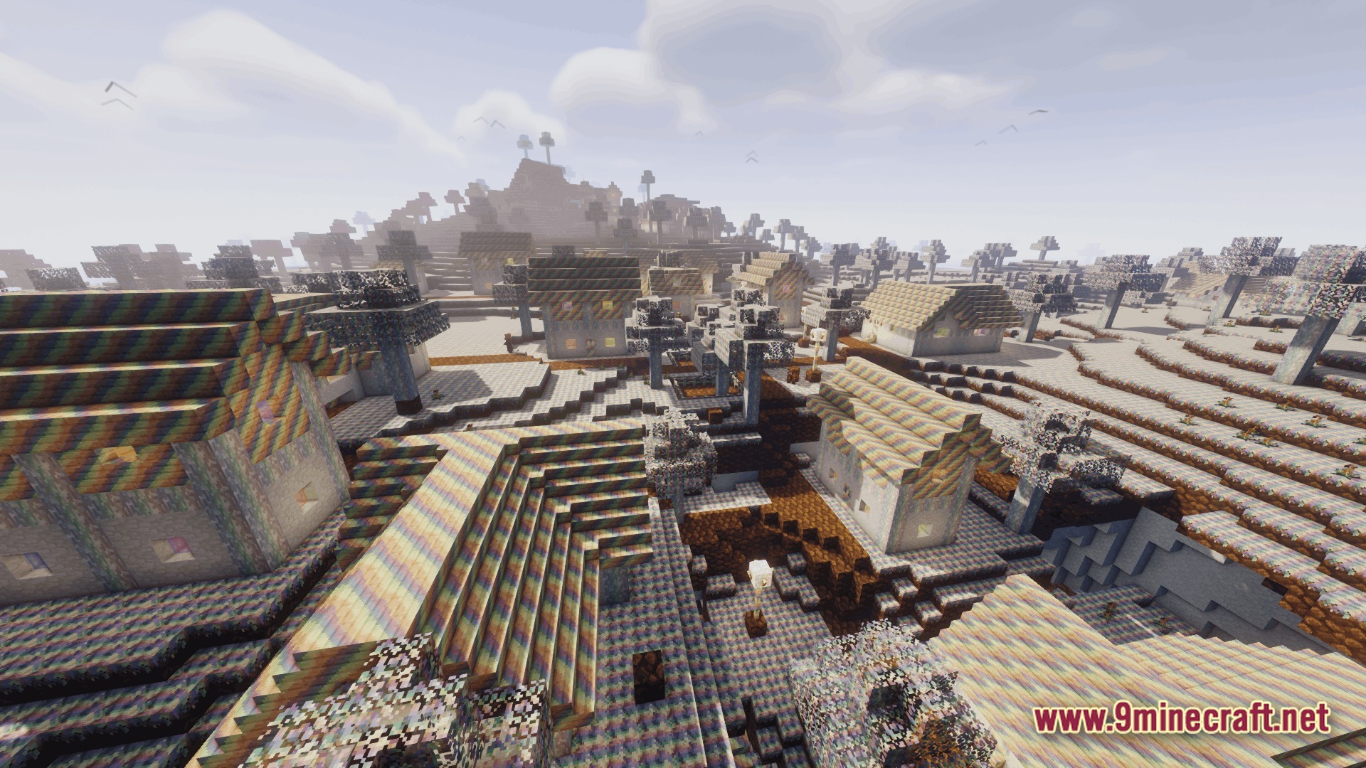 Ore Spawn Adventuree Modpack (1.20.1) – Crazy Dimensions And Giant Beasts 9 A village with rainbow-textured houses and trees situated in a hilly, multi-colored landscape