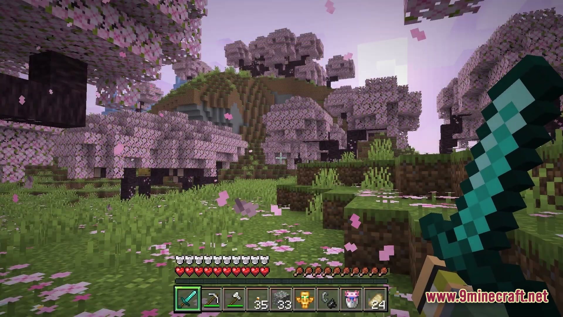A player holds a diamond sword while exploring a cherry blossom grove biome with falling petals