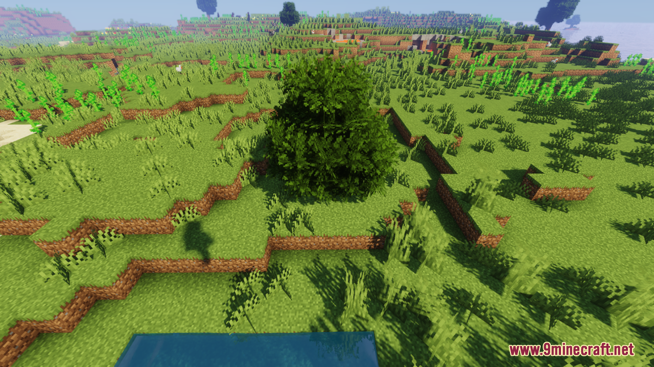 Rainbow’s Foliage Resource Pack (26.2, 1.20.1) – Bushier Leaves For Natural Forests 3 A lush green tree with bushy foliage grows on a grassy hill near water