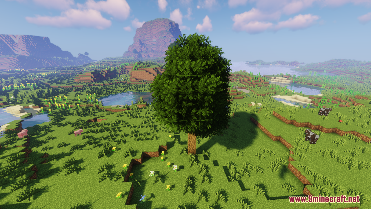 Rainbow’s Foliage Resource Pack (26.2, 1.20.1) – Bushier Leaves For Natural Forests 5 A tall bushy tree stands on a hill with mountains in the background