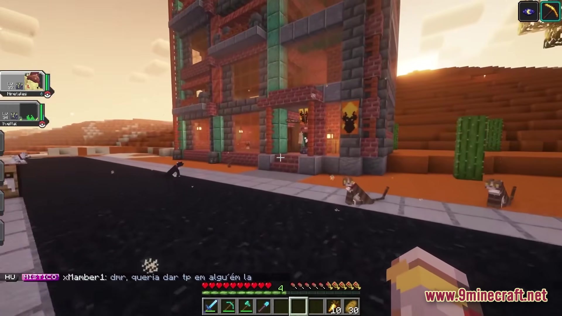 Servidor Jornadas Cobblemon Modpack (26.2, 1.21.1) – Your Ultimate Pokémon Minecraft Journey 6 A multi-story brick building stands next to an asphalt road in a desert biome with several cats