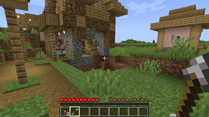 A player holds a shovel near a villager and a damaged house