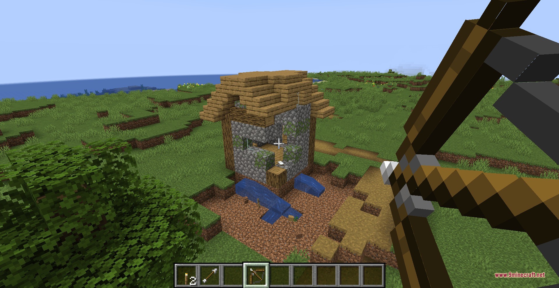 Player aiming a bow at a house using shatterbolt artillery data pack