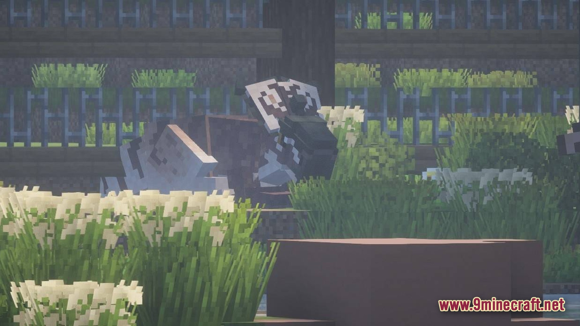 A patterned dinosaur stands behind tall grass and flowers within a fenced enclosure