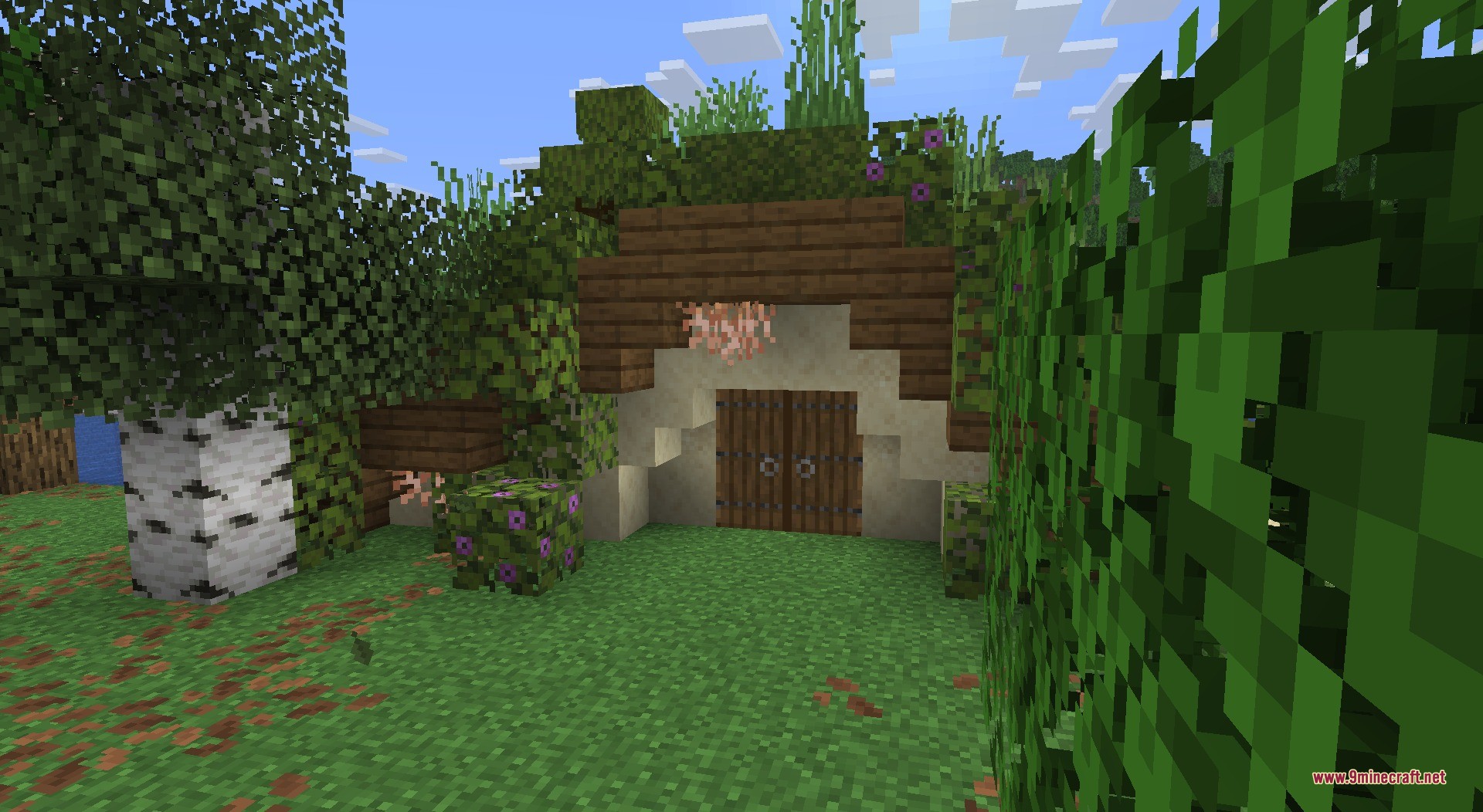 A cozy hobbit hole entrance built into a hill with lush greenery
