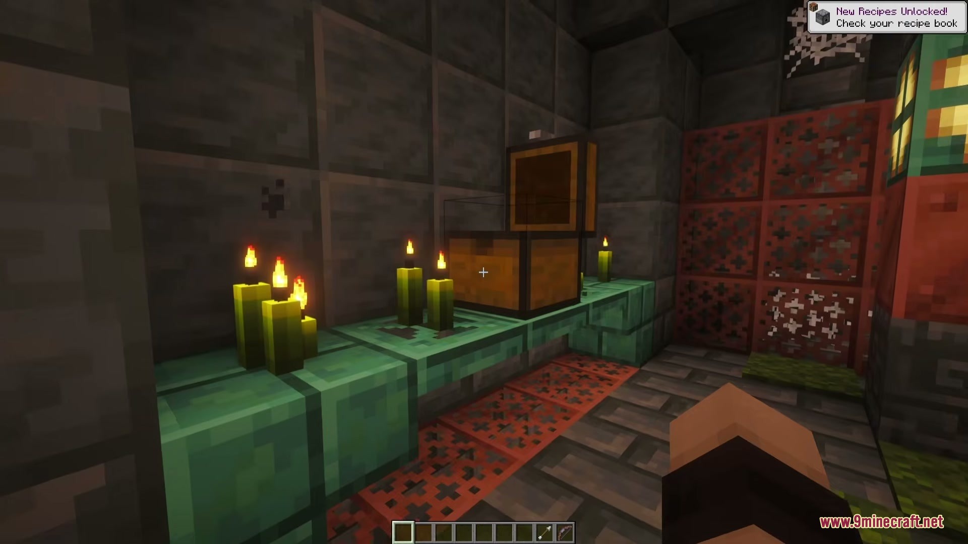 An open loot chest sitting on a copper shelf beside lit green candles