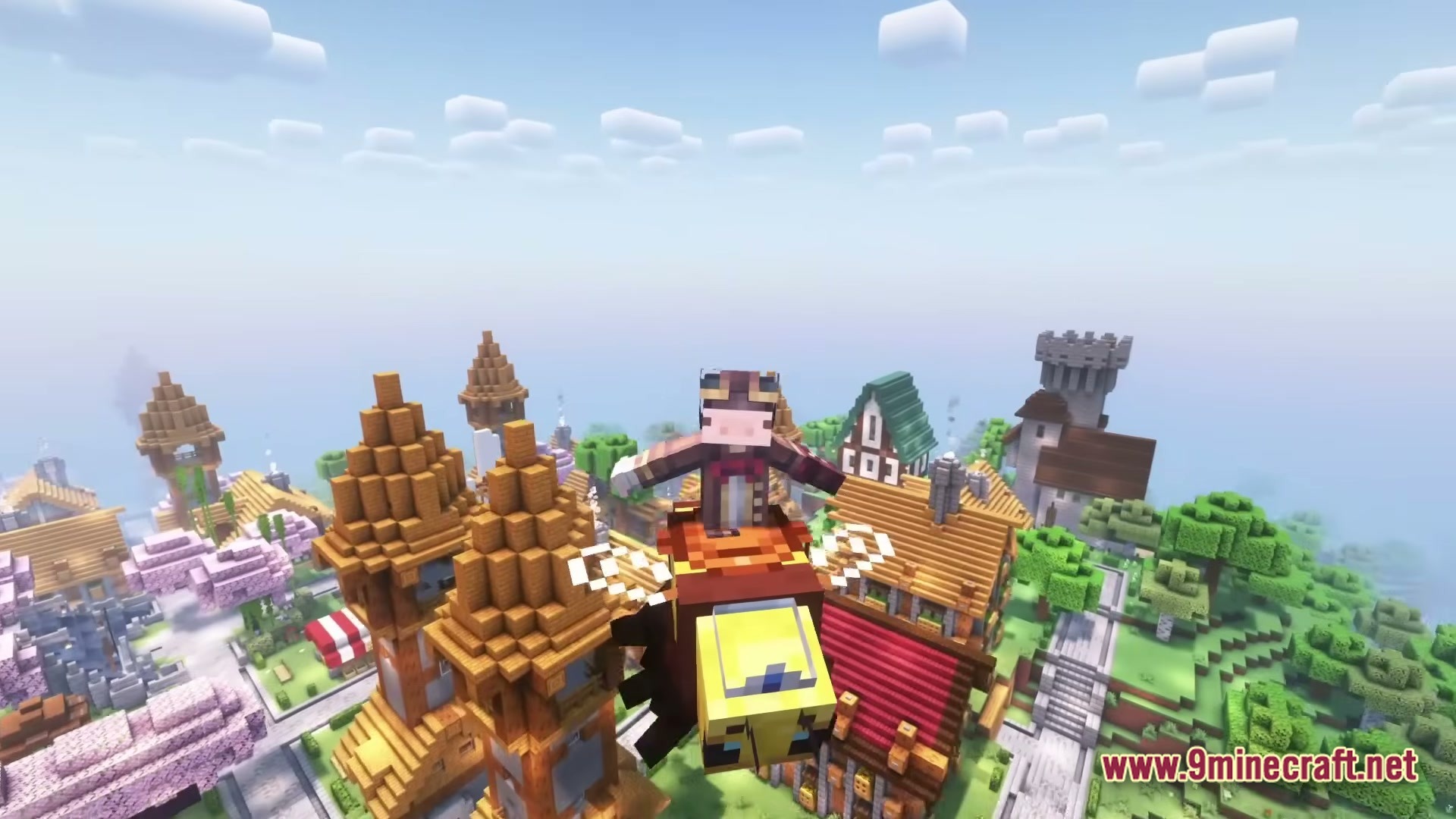 A player character flies a mechanical bee mount over a medieval village with various colorful buildings