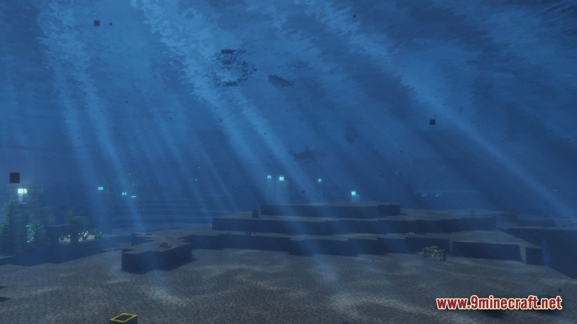 Sunlight filters through deep water onto an underwater landscape featuring stone structures and aquatic life