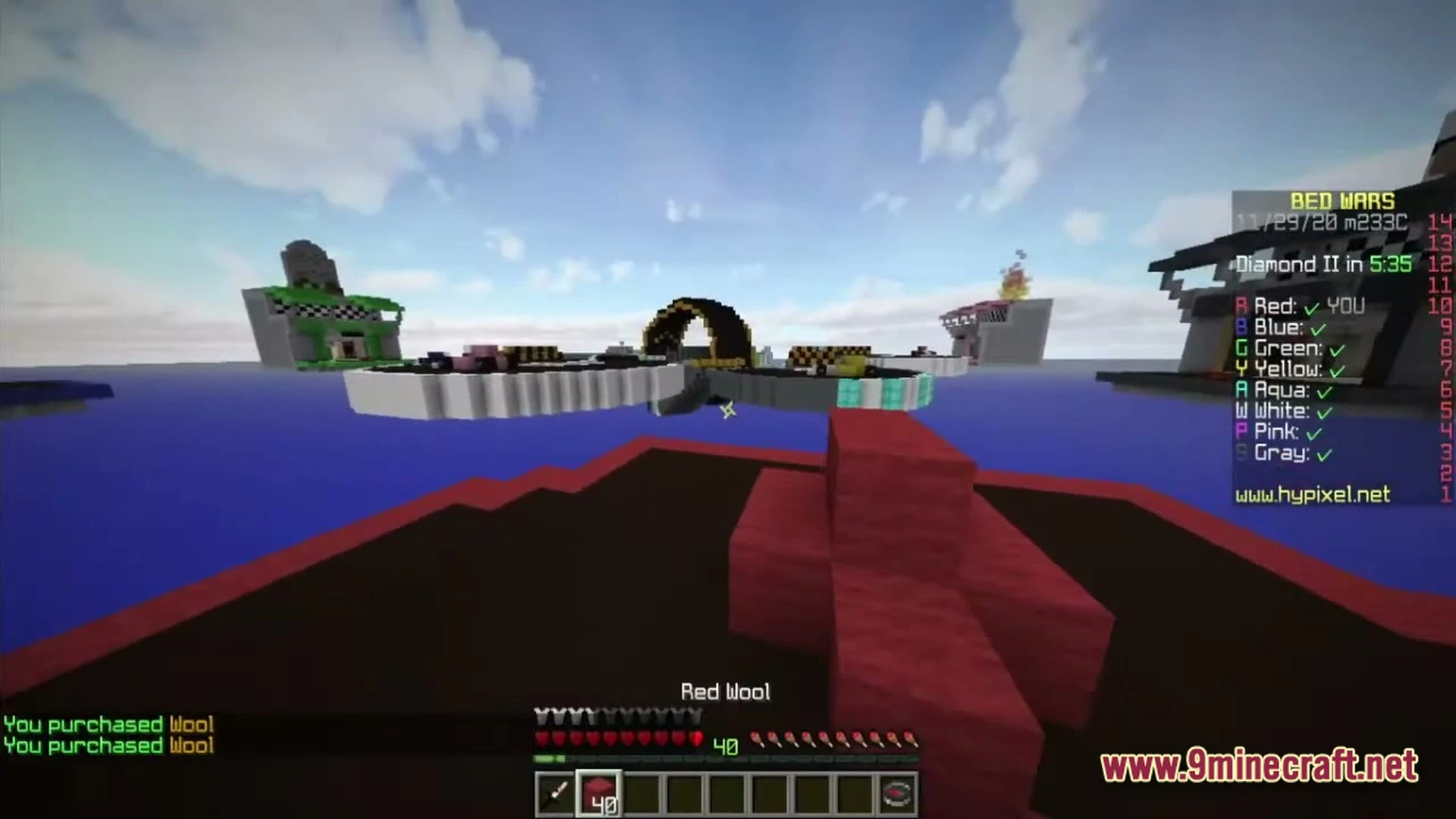 A player holds red wool while looking at floating islands during a bed wars match